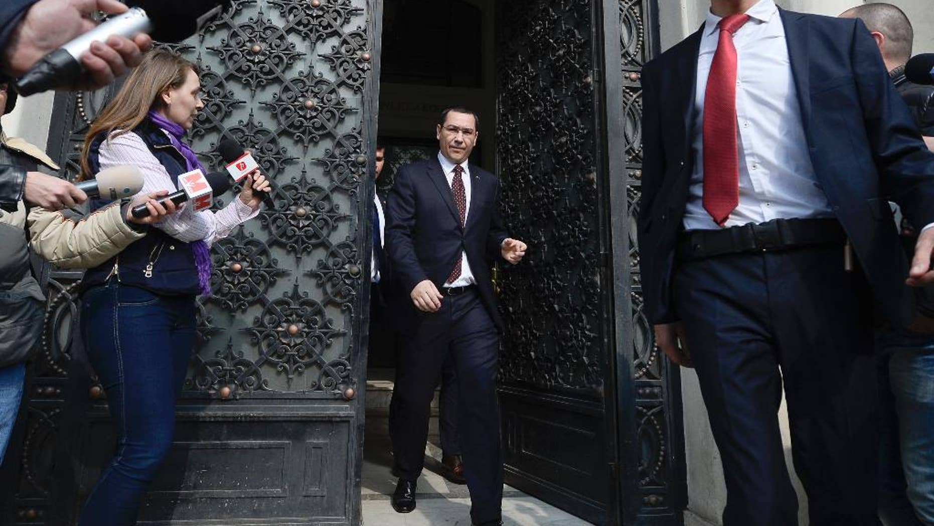 Romanian Premier Victor Ponta, center, is greeted by reporters as he exits the High Court of Cassation and Justice, in Bucharest, Romania, Wednesday, Mar. 11, 2015. Romania’s prime minister has appeared before the High Court of Cassation and Justice to give evidence in a probe into allegations of fraud during a referendum to impeach the former president. (AP Photo/Octav Ganea, Mediafax) ROMANIA OUT