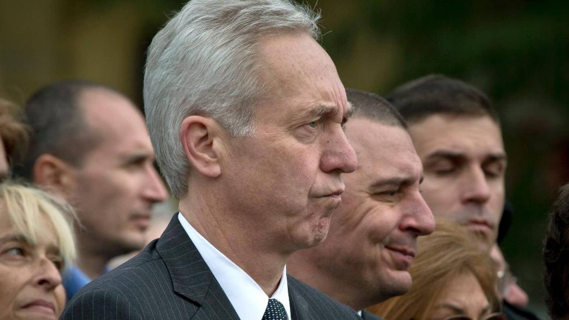 FILE - In this Oct. 8, 2015 photo from files, U.S. Ambassador Hans Klemm, center, attends a Holocaust memorial service in Bucharest, Romania. The United States’ ambassador to Romania speaking Tuesday, Oct. 13, 2015, at a conference organized by the American Chamber of Commerce, has urged politicians to continue reforms and stop political meddling in state-owned companies. (AP Photo/Vadim Ghirda, File)
