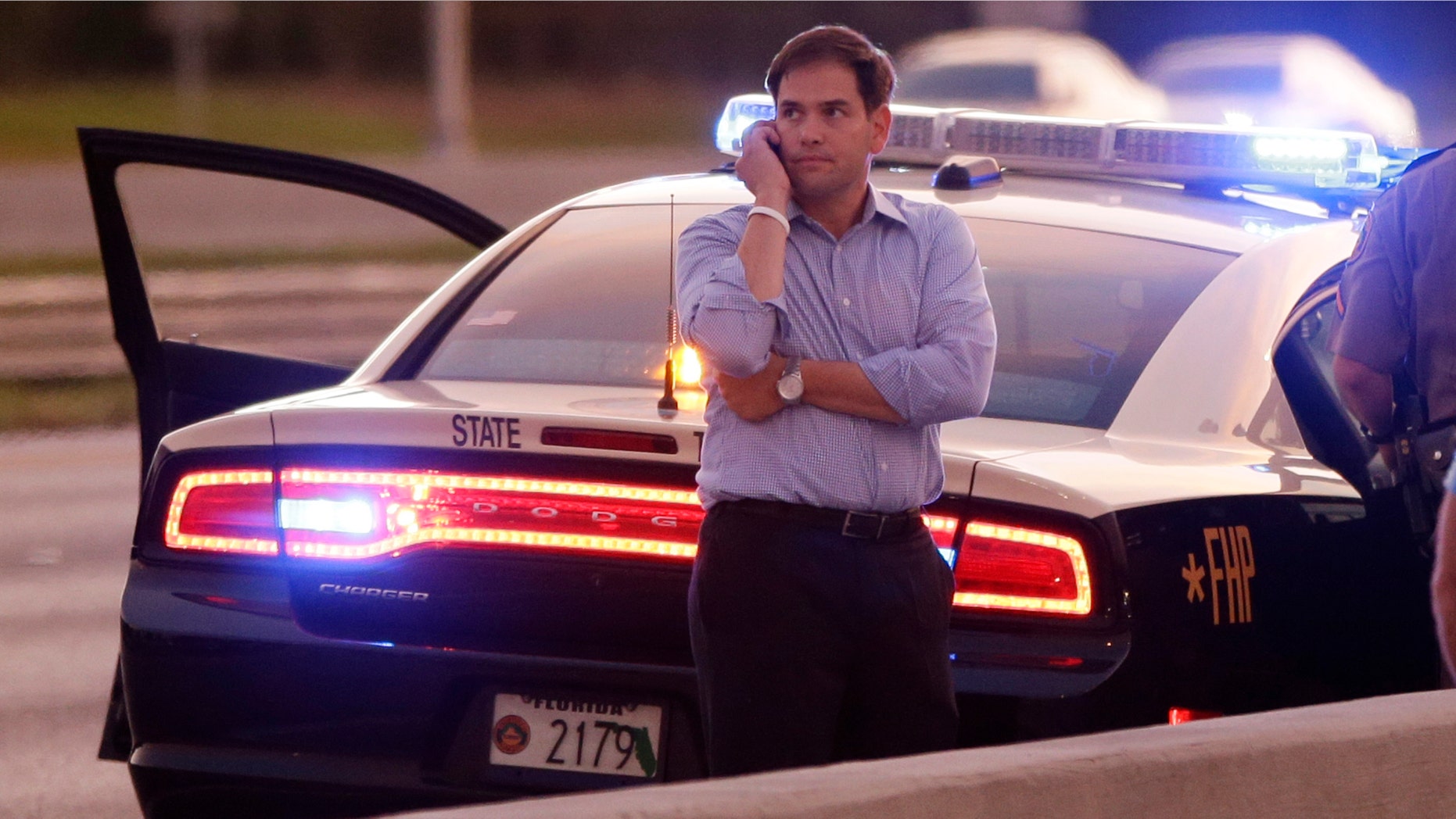 Sen. Marco Rubio, R-Fla., who is traveling with Republican presidential candidate and former Massachusetts Gov. Mitt Romney, uses a phone as he stands alongside Interstate 4 in Lakewood Crest, Fla., Saturday, Oct. 27, 2012 after the motorcade was stopped. The 12-year-old daughter of Sen. Rubio had been airlifted to a hospital after a Saturday motor vehicle accident. A Rubio spokesman reports that the girl is in stable condition. (AP Photo/Charles Dharapak)