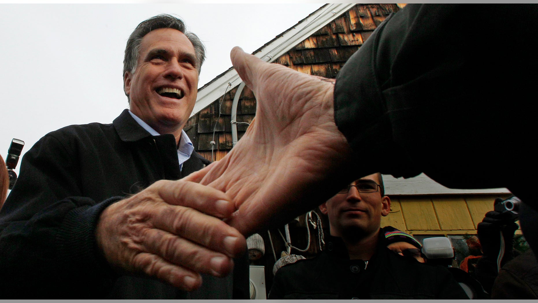 December 27, 2011: Republican presidential candidate and former Massachusetts Governor, Mitt Romney, shakes hands during a campaign stop in Portsmouth, N.H.