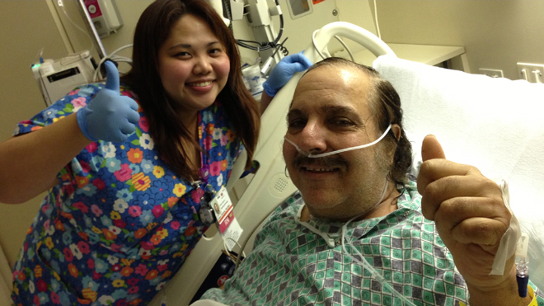 Ron Jeremy poses with one of his nurses while in the hospital.