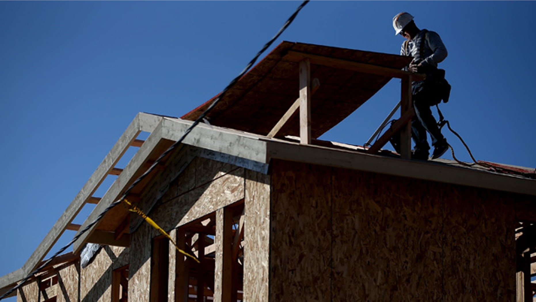 PETALUMA, CA - JANUARY 21: A worker walks on a roof as he builds a new home on January 21, 2015 in Petaluma, California. According to a Commerce Department report, construction of new homes increased 4.4 percent in December, pushing building of new homes to the highest level in nine years. (Photo by Justin Sullivan/Getty Images)