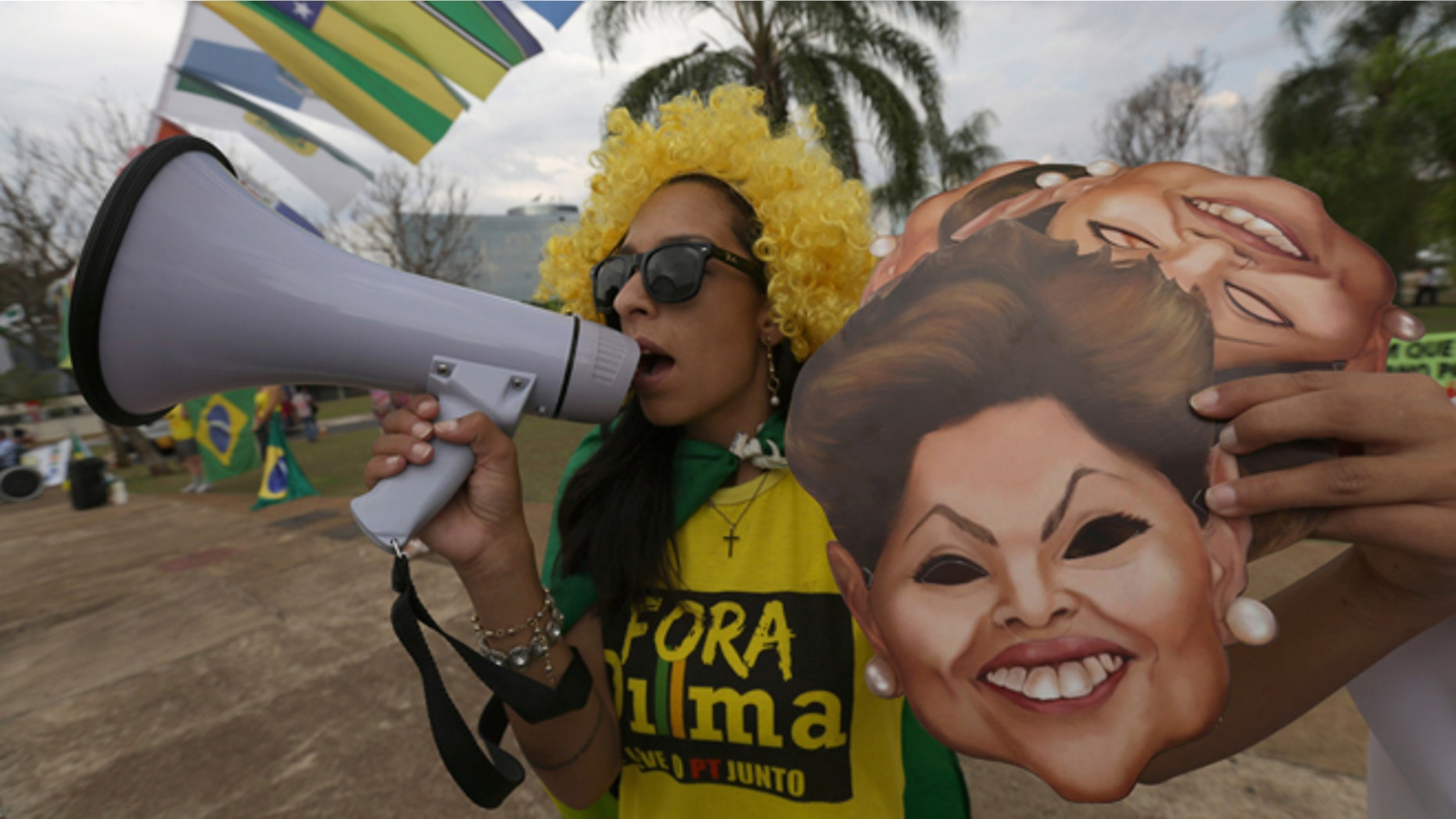 A demonstrator shouts slogans against Brazilian President Dilma Rousseff with a bullhorn outside the headquarters of the the Federal Court of Accounts in Brasilia, Brazil, Wednesday, Oct. 7, 2015. The Court decides today whether to approve the government accounts of the President Rousseff for 2011-214. Political opposition parties are accusing Rousseff of concealing information about her government's accounts. (AP Photo/Eraldo Peres)
