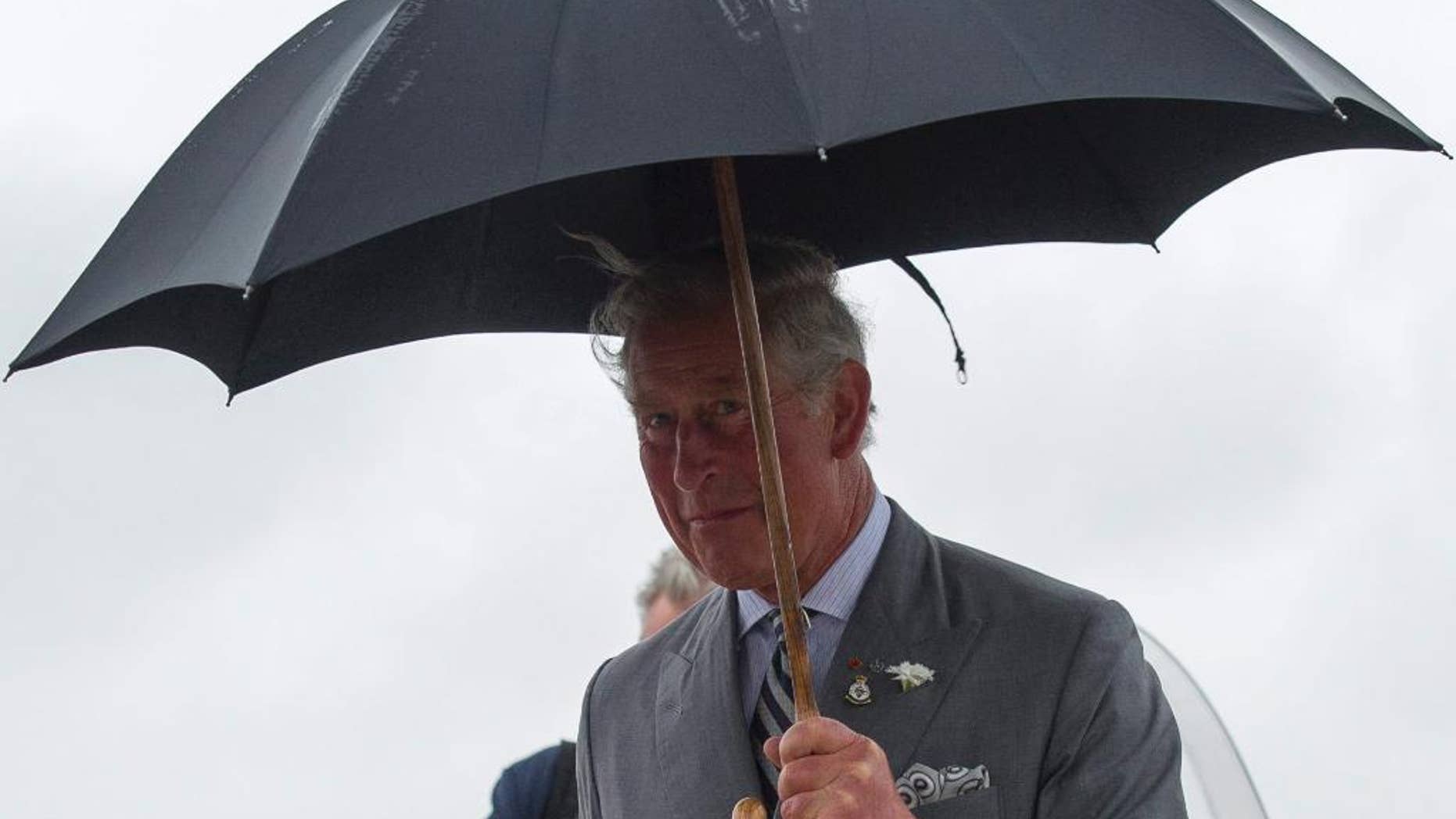 Prince Charles arrives in the rain at a Canadian Forces Base airport in Winnipeg, Canada, May 20, 2014 (AP Photo/The Canadian Press, David Lipnowski)