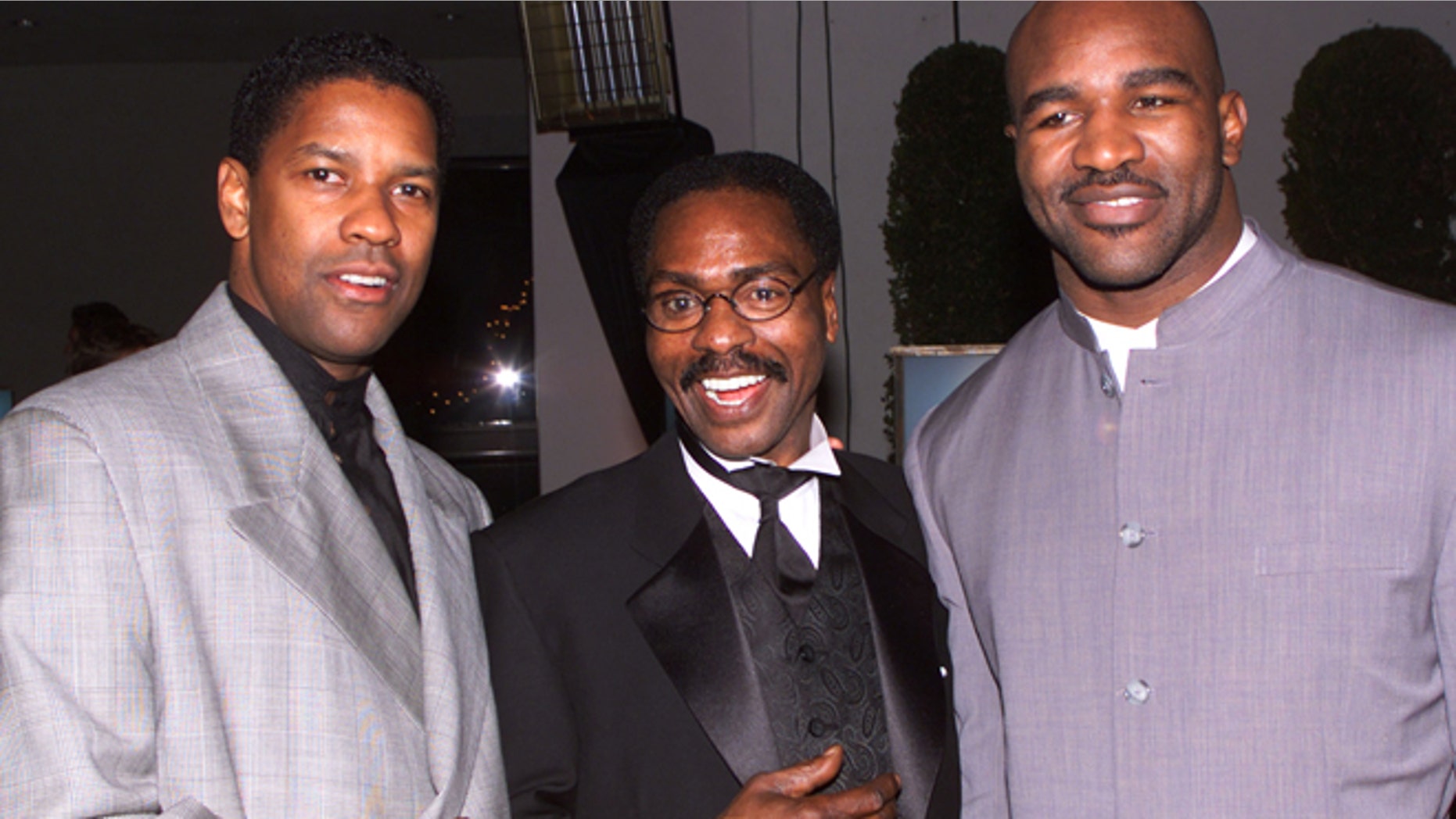 Dec. 14, 1999: Actor Denzel Wahington (L), star of the film "The Hurricane," based on the true story of Rubin "Hurricane" Carter (C), an innocent man who fought for 20 years for justice, poses at the film's premiere party in Los Angeles with boxing champion Evander Holyfield.