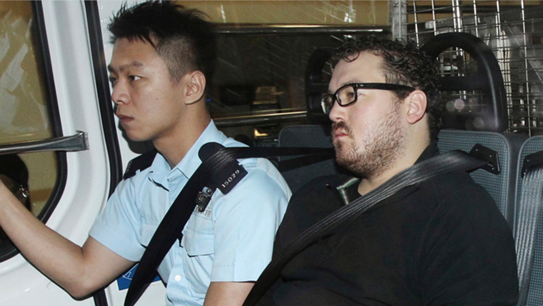 Nov. 3, 2014: Rurik George Caton Jutting, right, is escorted by a police officer in an police van before appearing in a court in Hong Kong.