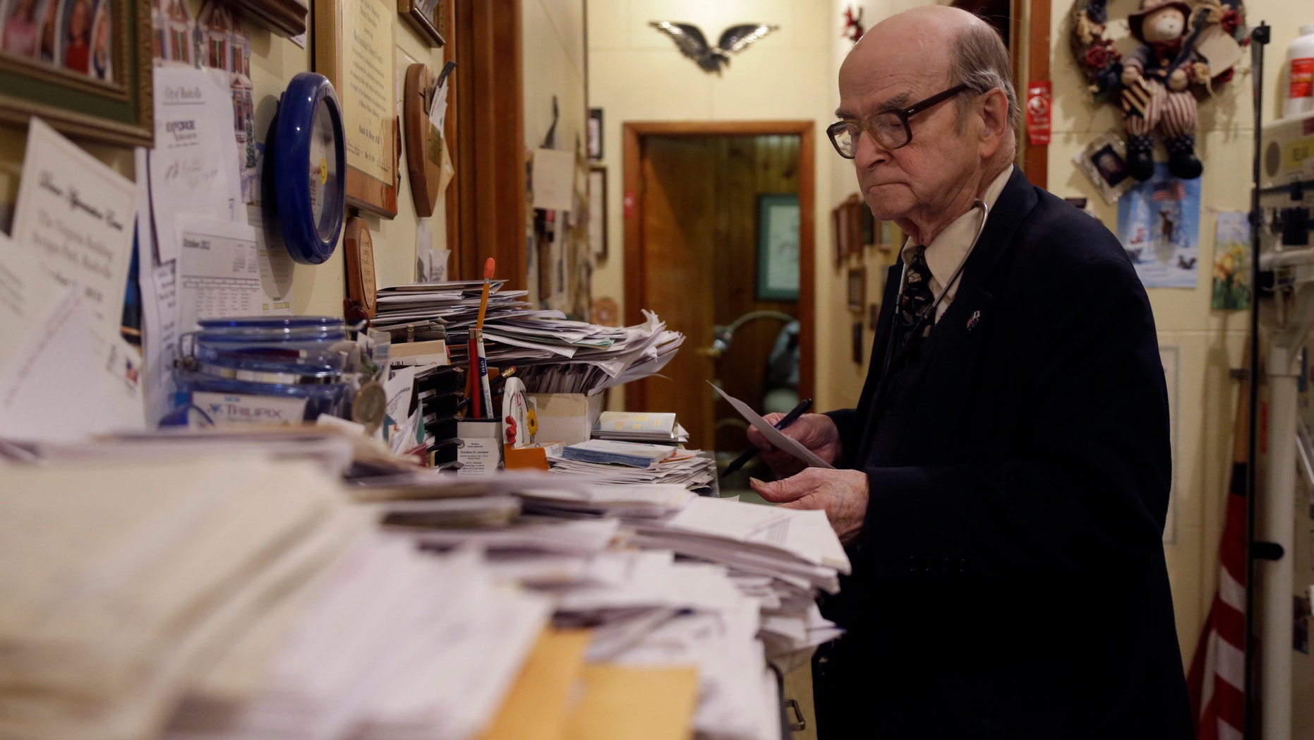 Oct. 30, 2012: Dr. Russell Dohner looks over paper records between seeing patients in Rushville, Ill. (Jeff Roberson/AP)