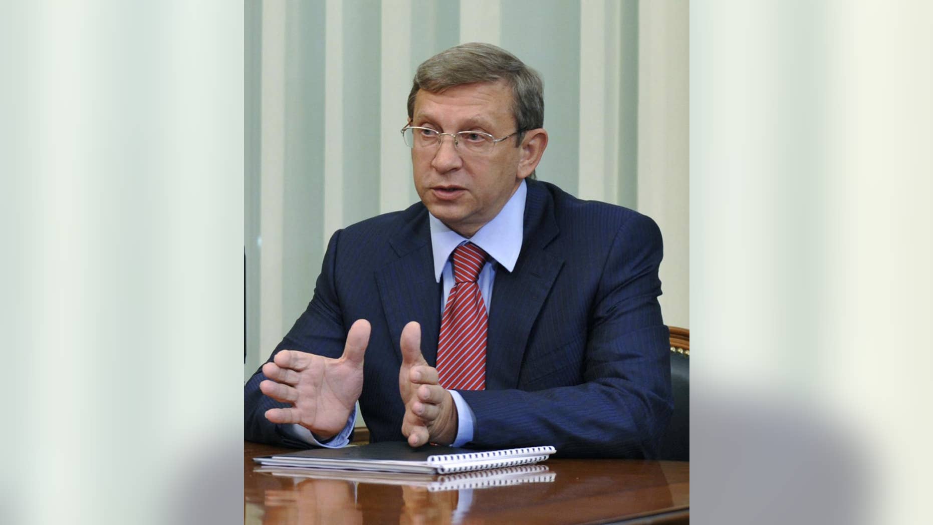 FILE- In this Tuesday, May 5, 2009 file photo Russian tycoon Vladimir Yevtushenkov, owner of Sistema Holding, speaks during a meeting with then Russian Prime Minister Vladimir Putin in Moscow, Russia. The arrest of the Russian billionaire has sent shares in his holding company into a tailspin Wednesday morning, Sept. 17, 2014. Yevtushenkov, who is worth $9 billion according to the Russian Forbes magazine, was placed under house arrest late Tuesday, Sept. 16, in a money-laundering case which has drawn comparisons with a government crackdown on the Yukos oil company more than a decade ago. (AP Photo/RIA Novosti, Alexei Druzhinin, Presidential Press Service, File)