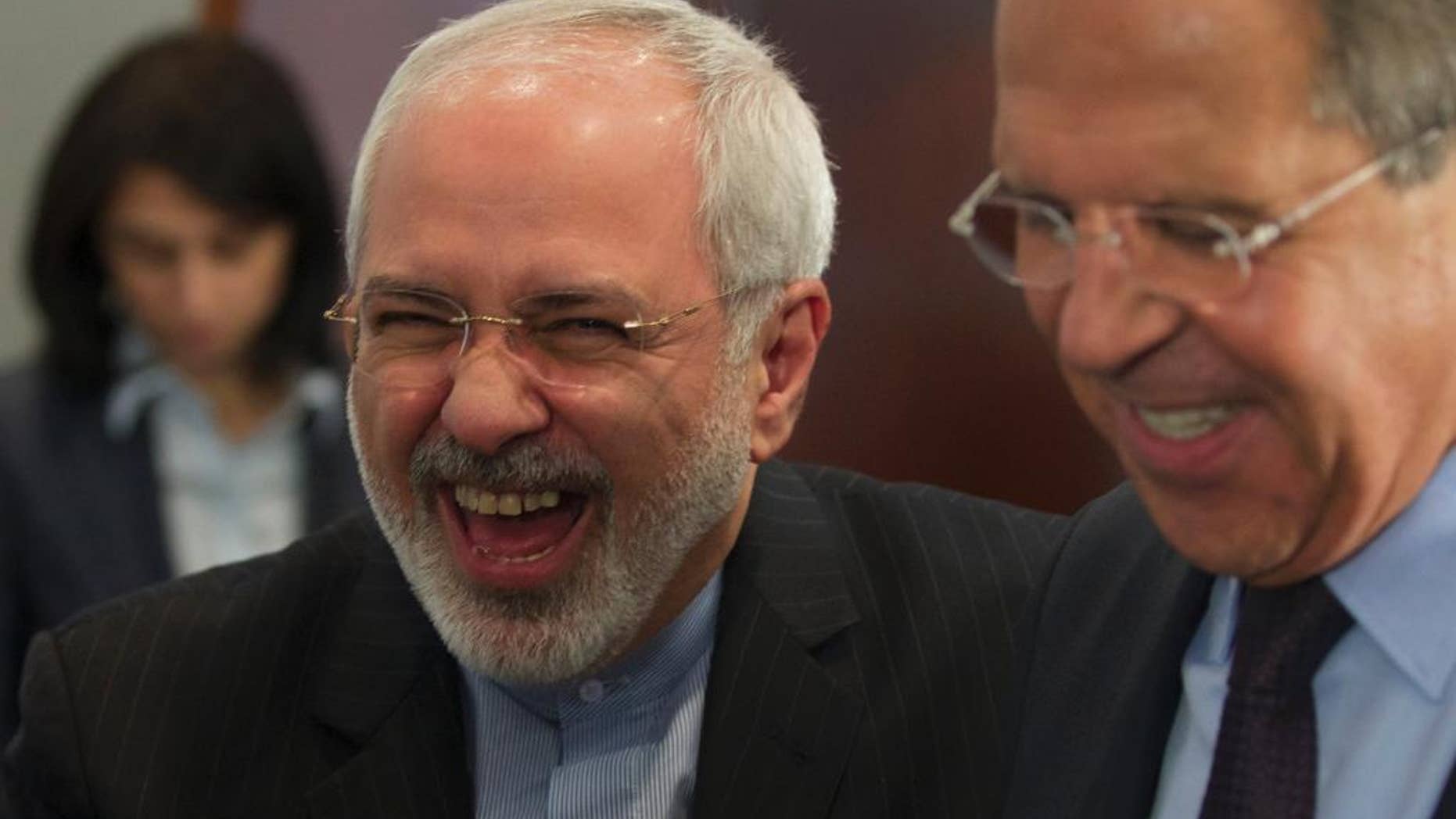 Iranian Foreign Minister Mohammad Javad Zarif, left, laughs with his Russian counterpart Sergey Lavrov after the meeting of foreign ministers from Caspian countries, in Moscow, Russia on Tuesday, April 22, 2014. (AP Photo/Ivan Sekretarev)