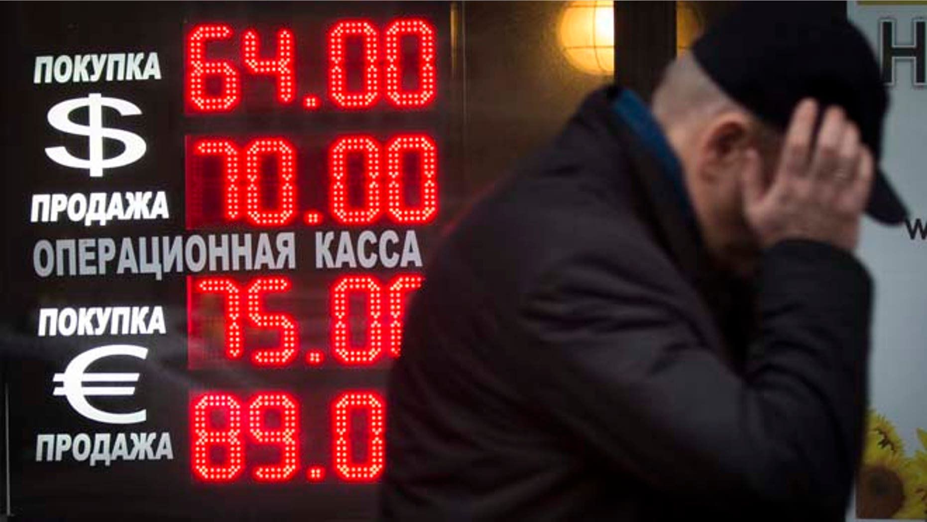Dec. 16, 2014: Signs advertising currencies light next to the exchange office in Moscow, Russia. After a massive overnight rate hike by Russia's Central Bank, the ruble staged a two-hour rally Tuesday morning before rolling back to new historic lows.