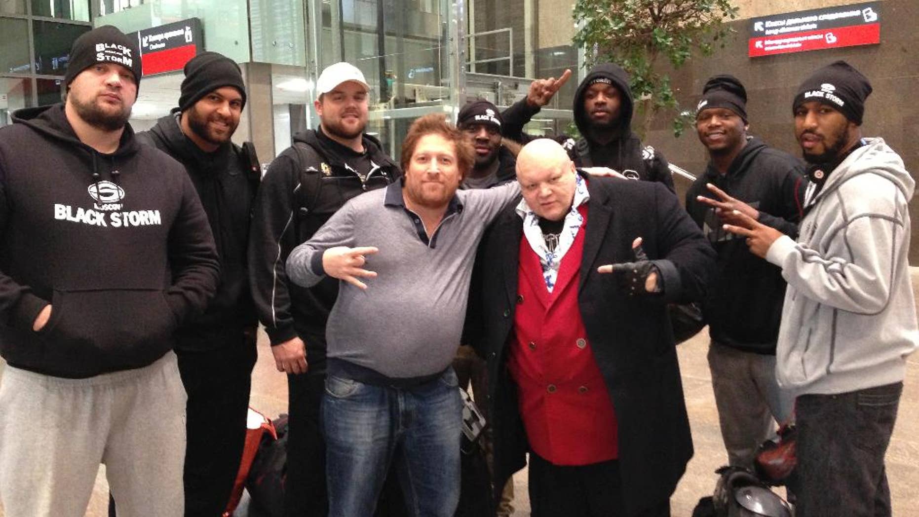 Oct. 14, 2013- FILE photo of Mikhail Zaltsman, (center in grey sweater,) lawyers, and players of the Black Storm American football team in Moscow, after winning the Russian championship in St. Petersburg, Russia. Accused of breaking a window, American businessman Zaltsman now shares a packed jail cell with drug dealers.