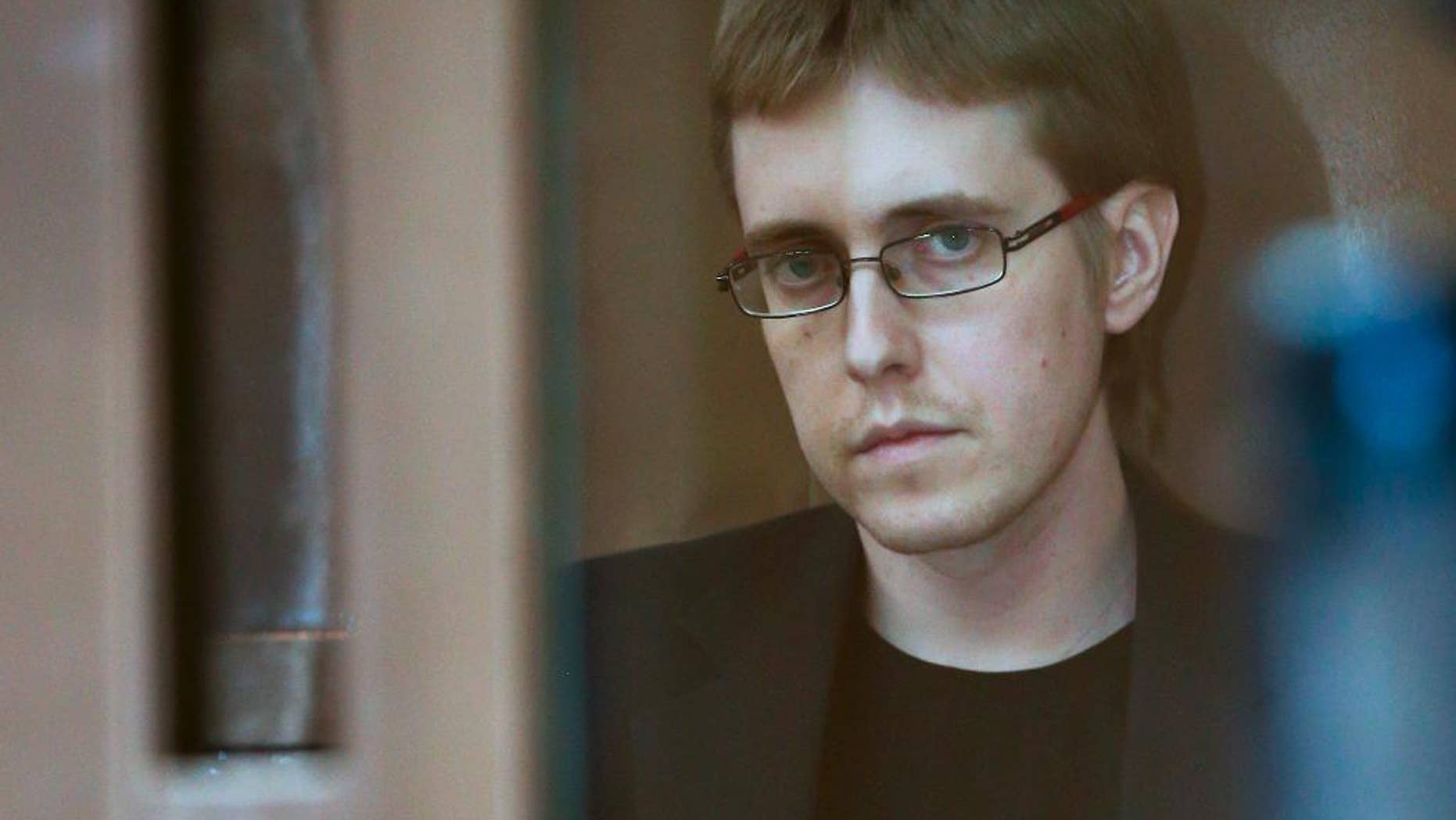 Ilya Goryachev looks from a defendants' cage in a courtroom in Moscow, Russia, Friday, July 24, 2015. Moscow’s highest court on Friday sentenced Ilya Goryachev, a leader of a militant neo-Nazi group, to life in prison after he was convicted of ordering five brutal killings including that of a prominent human rights lawyer. (AP Photo)