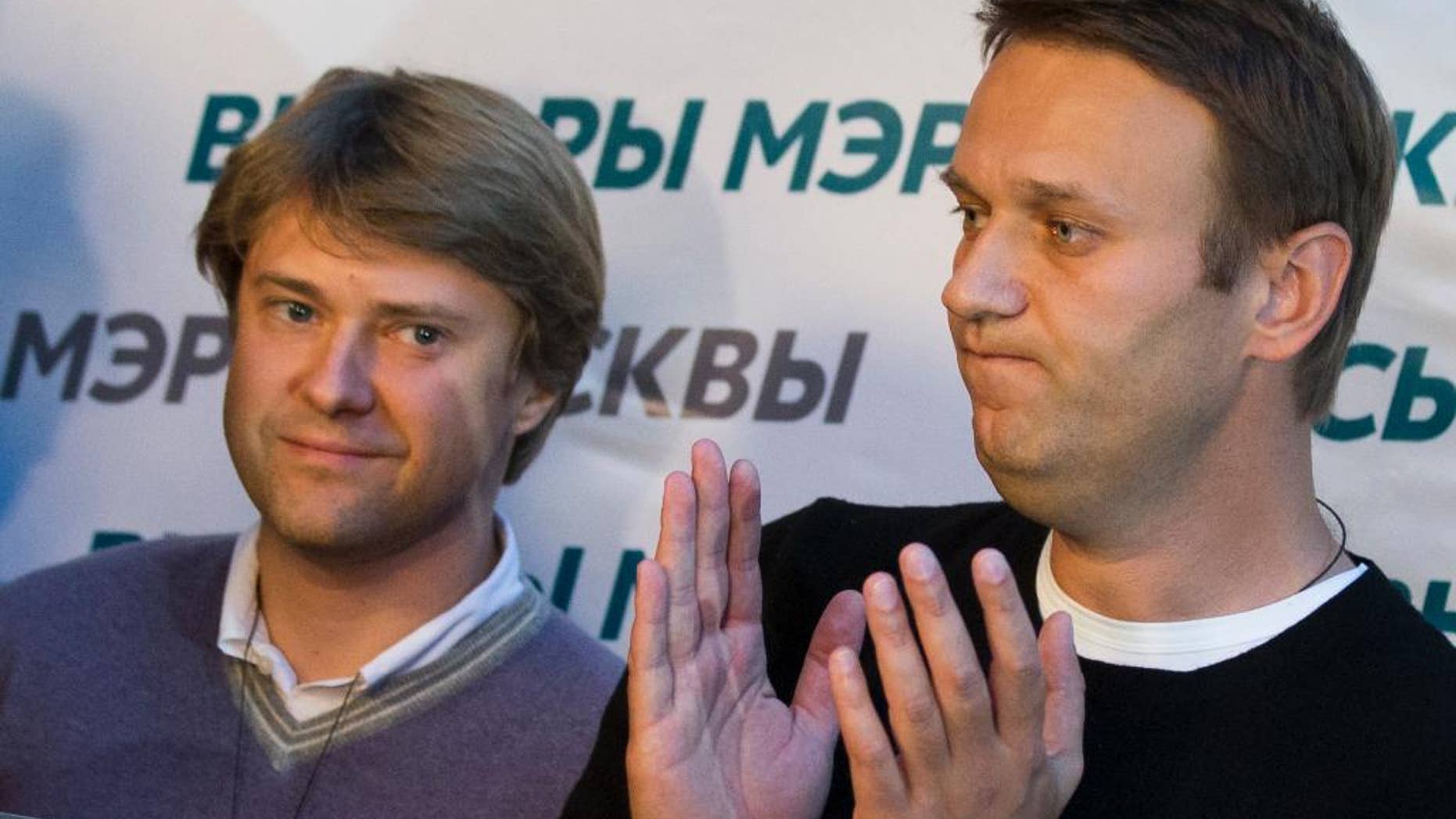 In this photo taken on Sunday, Sept. 8, 2013, Vladimir Ashurkov, left, a top aide of top Russian opposition leader and anti-corruption blogger Alexei Navalny, right, who has been under house arrest since February 2014, attends a news conference at his headquarters in Moscow, Russia. Vladimir Ashurkov wrote on Twitter Monday that he had requested asylum in the United Kigdom "due to political persecution" by authorities. Ashurkov didn't say whether he had yet received a response from British authorities. (AP Photo/Alexander Zemlianichenko)