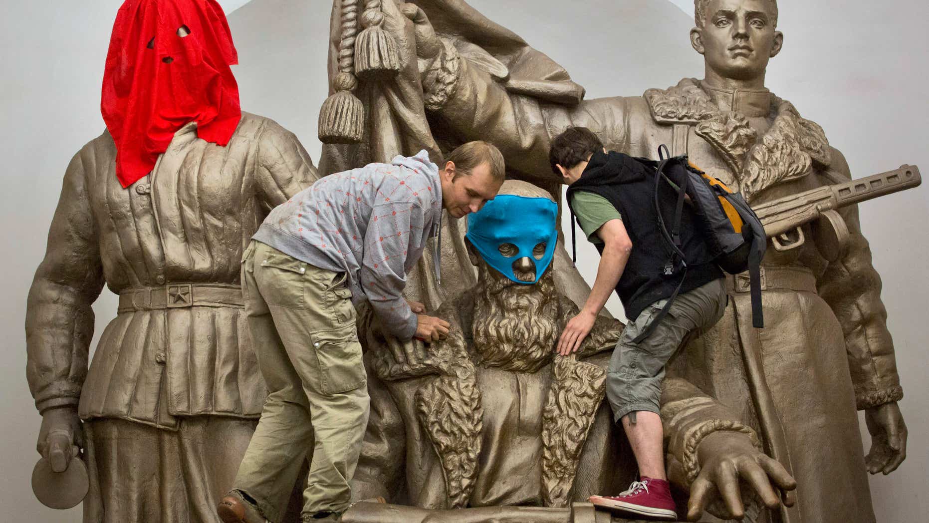Aug. 17, 2012: Pussy Riot punk group supporters place masks on a monument to WWII heroes to resemble Pussy Riot members, at an underground station in Moscow.