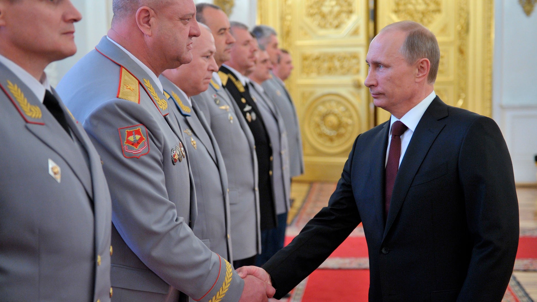 Russian President Vladimir Putin, right, shakes hands at the presentation ceremony of the top military brass in the Kremlin in Moscow, Friday, June 7, 2013. (AP Photo/RIA-Novosti, Alexei Nikolsky, Presidential Press Service)