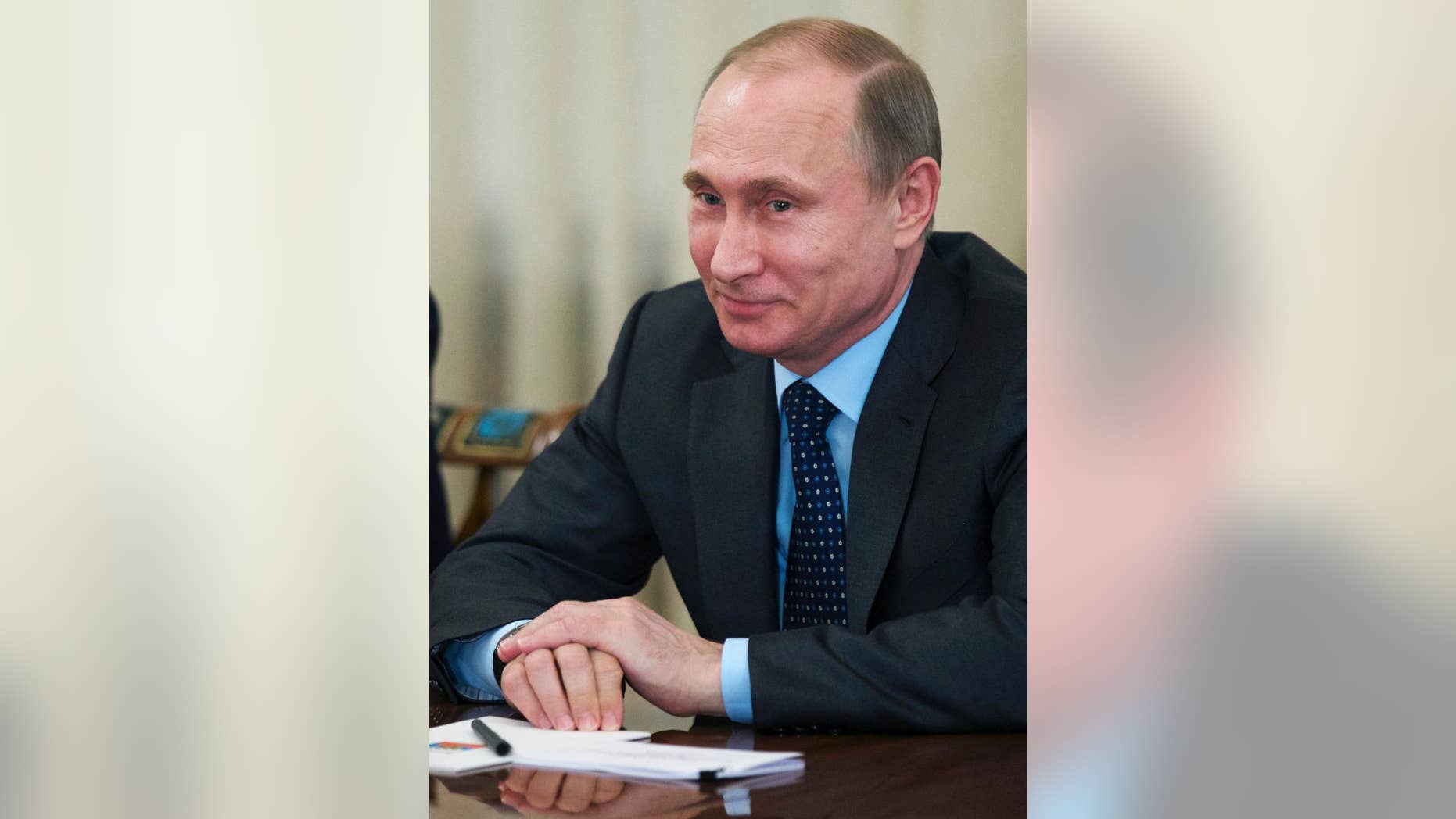 Russian President Vladimir Putin smiles as he listens to the CEO of Siemens AG Joe Kaeser during their meeting in the Novo-Ogaryovo residence outside Moscow, Russia, Wednesday, March 26, 2014. Kaeser told President Vladimir Putin on Wednesday the German industrial giant plans long-term investment in Russia, in a key sign of confidence in Russia's economy despite the outcry over its intervention in Crimea. (AP Photo/Alexander Zemlianichenko, Pool)