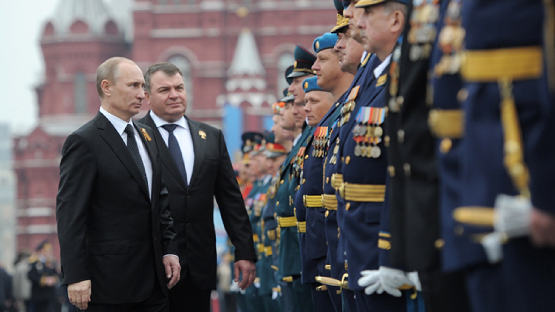 May 9, 2012: Russian President Vladimir Putin, left, and Defense Minister Anatoly Serdyukov, second left, speaks with officers and WWII veterans on the Red Square, after the Victory Day Parade, which commemorates the 1945 defeat of Nazi Germany in Moscow, Russia.