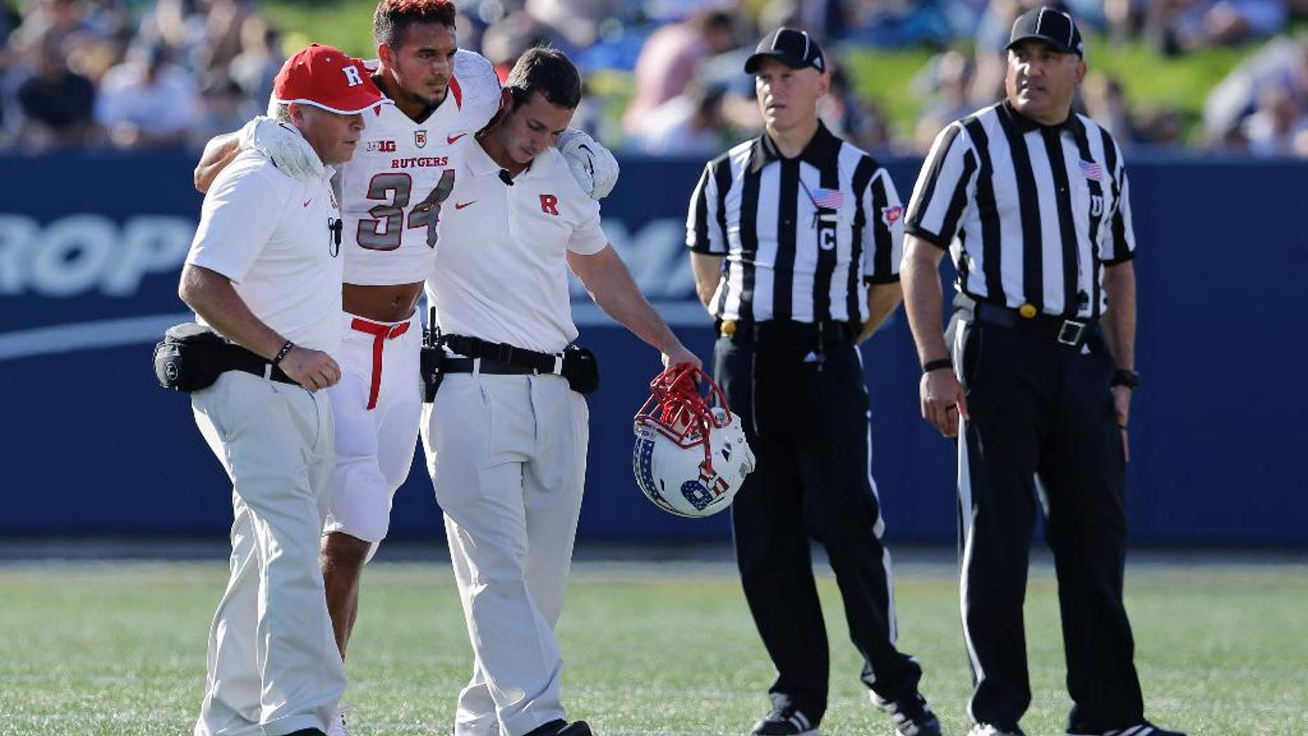 Rutgers running back Paul James (34) is assisted off the field after a play in the first half of an NCAA college football game against Navy in Annapolis, Md., Saturday, Sept. 20, 2014. He did not return to the game. (AP Photo/Patrick Semansky)