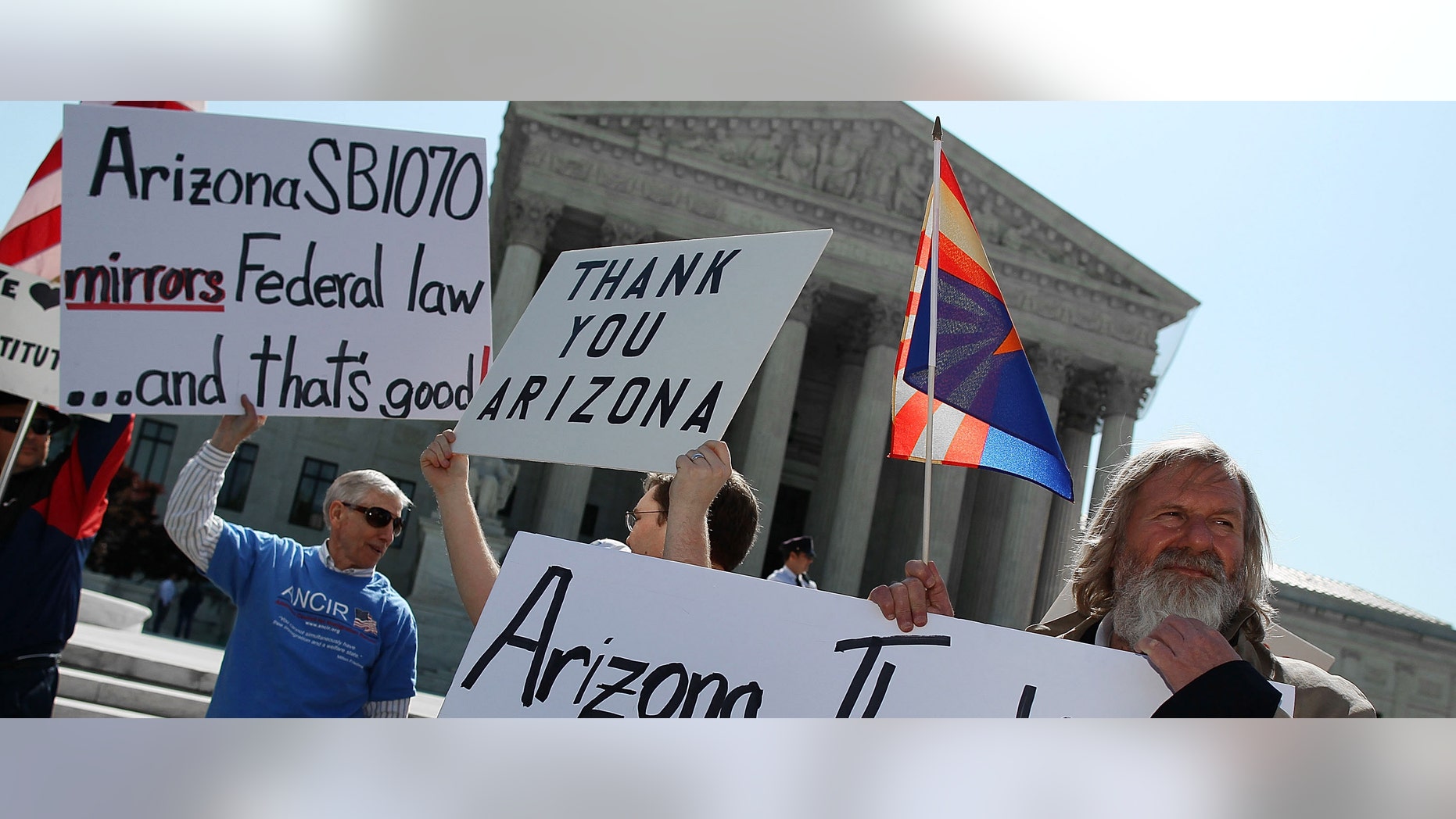 WASHINGTON, DC - APRIL 25: People protest in front of the U.S. Supreme Court, on April 25, 2012 in Washington, DC. Later this morning the high court will hear arguments on Arizona v. United States and will be tasked with deciding the conflicting roles of national and state governments in controlling the lives of noncitizens living illegally in the U.S. while deciding the constitutionality of Arizona's immigration law SB 1070. (Photo by Mark Wilson/Getty Images)