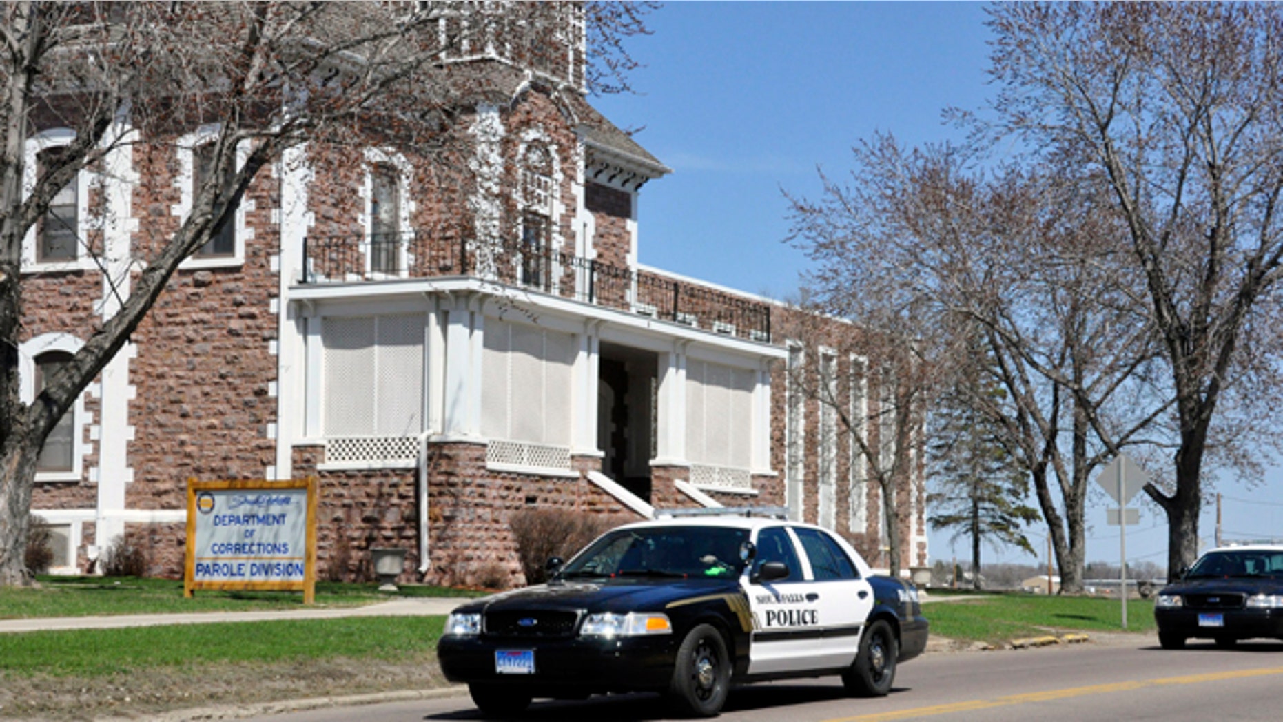 April 12, 2011: Two police cruisers leave the South Dakota State Penitentiary where a guard was shot and killed during a failed escape attempt in Sioux Falls, S.D. The two suspects in the case were apprehended.