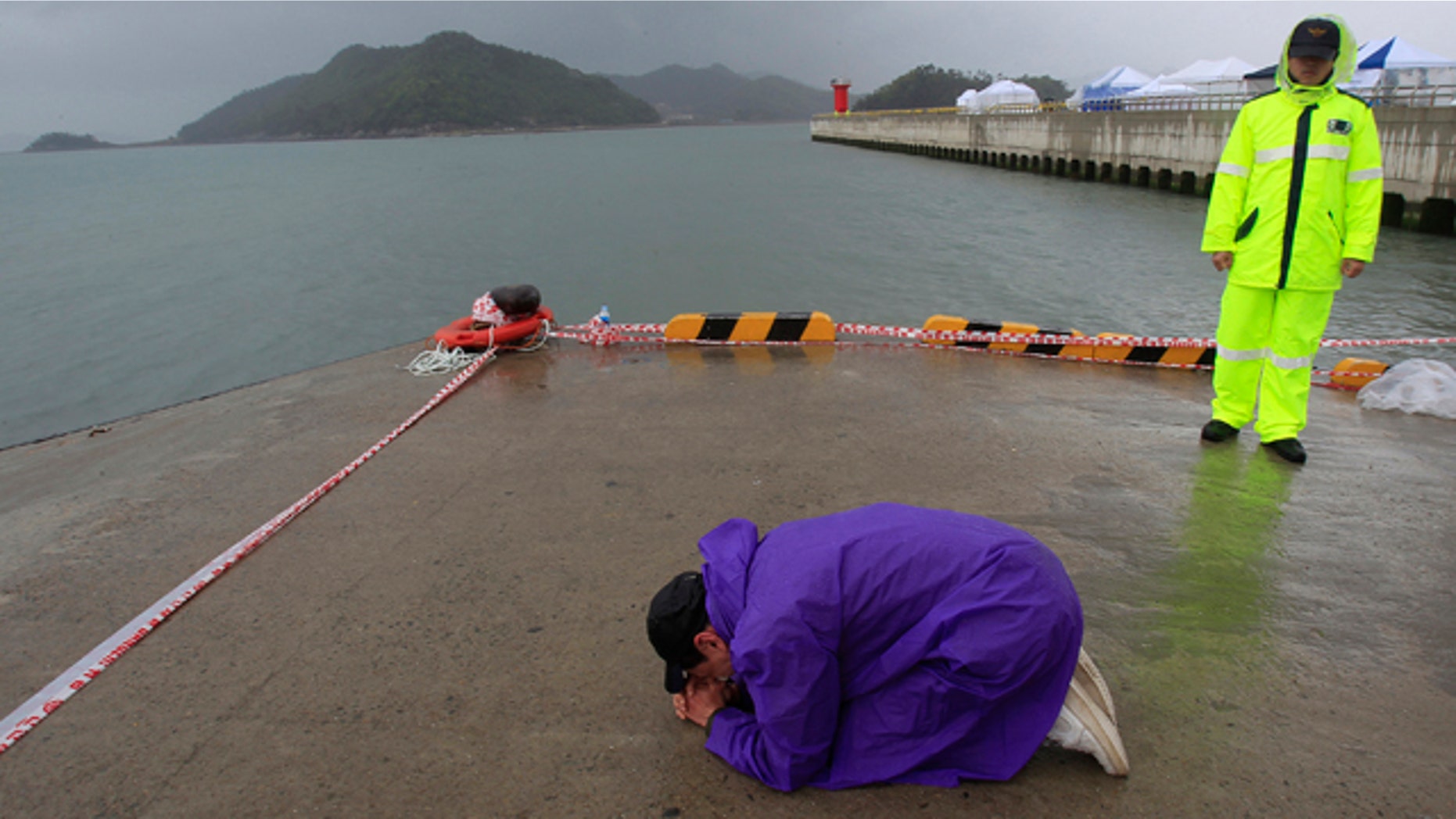 April 27, 2014: A relative of a passenger aboard the sunken Sewol ferry prays as he awaits news on his missing loved one at a port in Jindo, South Korea. (AP Photo/Ahn Young-joon)