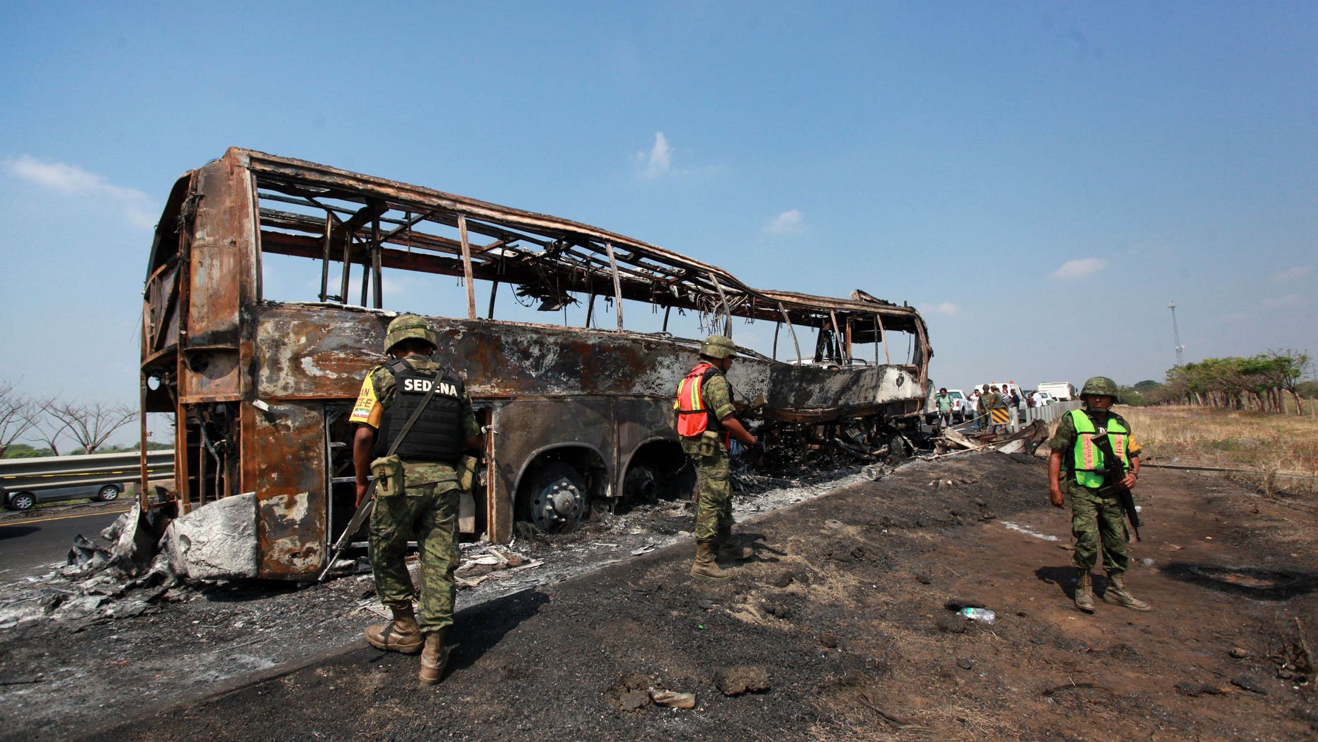 April 13, 2014 - Soldiers guard the site where a passenger bus slammed into a broken-down truck and burst into flames near the town of Ciudad Isla in the Gulf state of Veracruz, Mexico. Dozens of people traveling on the bus to Mexico City burned to death inside the bus.