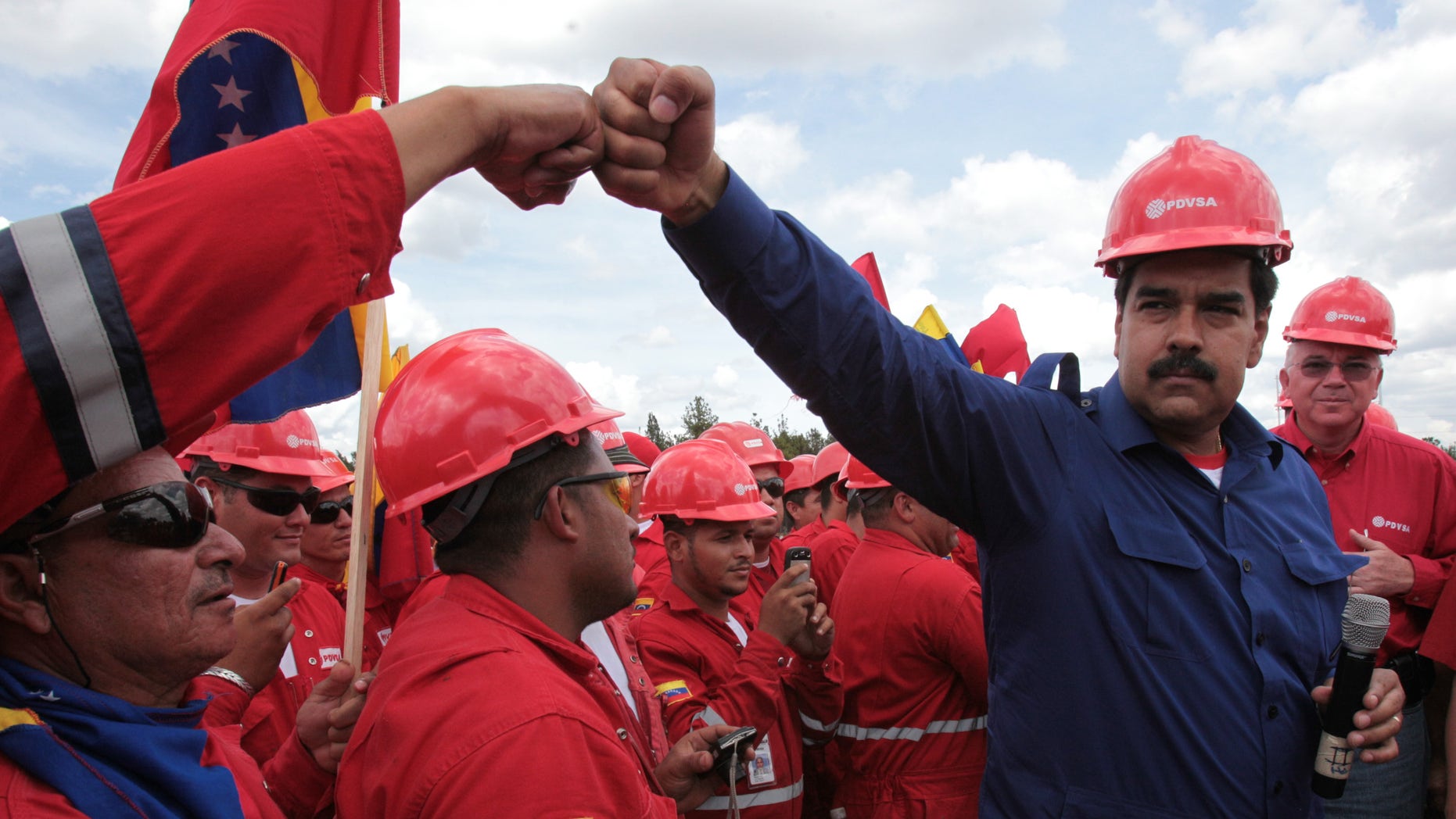 The candidate for president of Venezuela Nicolas Maduro greets a worker during a visit to a state oil company PDVSA's facility in the Orinoco Basin March 21, 2013. (AP Photo/Miraflores Presidential Office)