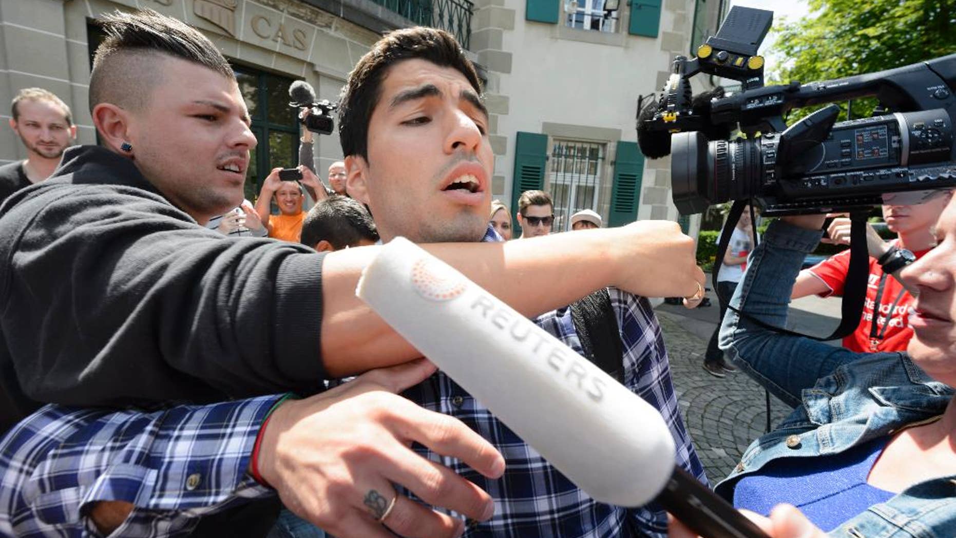 El atacante uruguayo del Barcelona Luis Suárez habla con medios de comunicación a su salida de una audiencia en el Tribunal de Arbitraje Deportivo el viernes 8 de agosto de 2014 en Lausana, Suiza. (Foto de AP/Keystone, Laurent Gillieron)