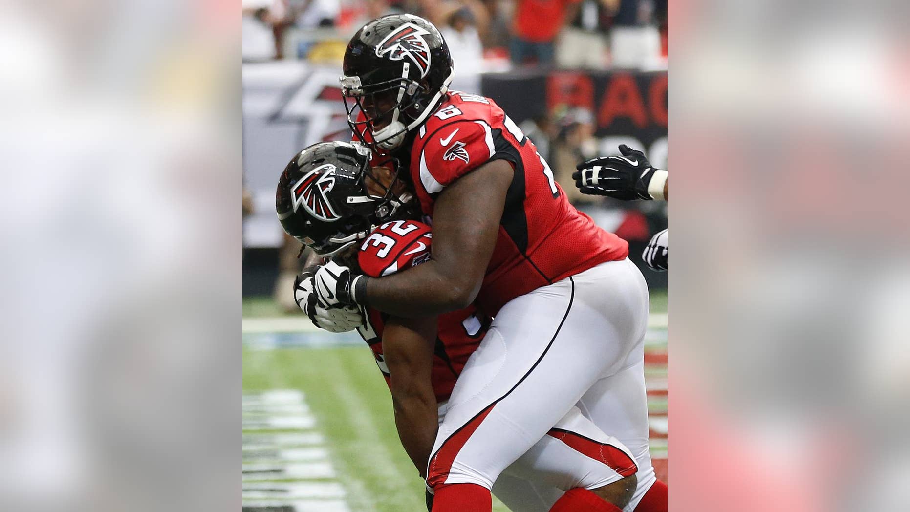 Atlanta Falcons tackle Lamar Holmes (76) embraces Atlanta Falcons running back Jacquizz Rodgers (32) after Rodgers scored a touchdown against the New Orleans Saints during the second half of an NFL football game, Sunday, Sept. 7, 2014, in Atlanta. (AP Photo/John Bazemore)