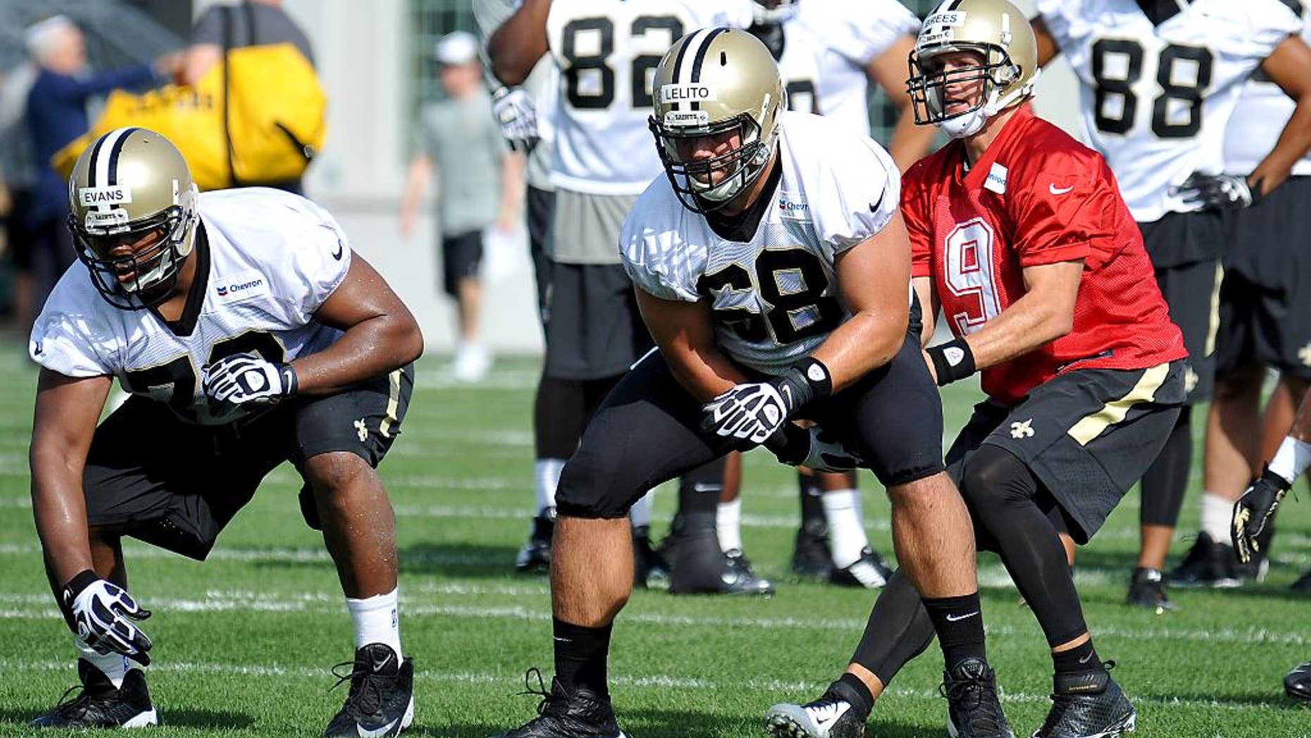 FILE - In this July 25, 2014, file photo, New Orleans Saints quarterback Drew Brees (9) takes a snap from center Tim Lelito (68) during NFL football training camp in White Sulphur Springs, W.Va. Lelito, a second-year pro, filled in for injured starter Jonathan Goodwin in the second half of their week 3 victory over Minnesota. (AP Photo/Chris Tilley, File)