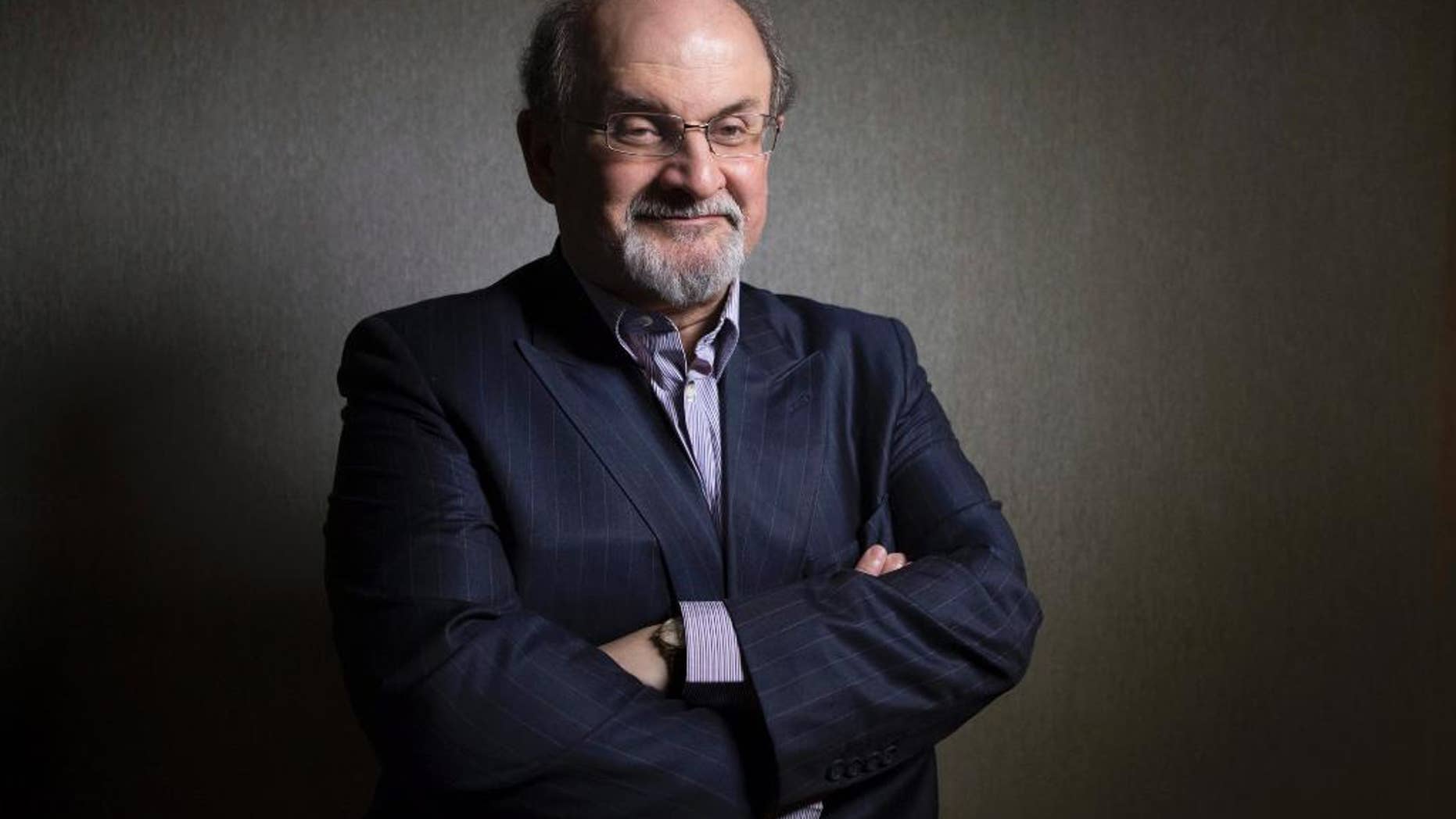 FILE - This Sept. 8, 2012 file photo shows author Salman Rushdie posing during the 2012 Toronto International Film Festival in Toronto. Rushdie who lived for years under a death threat after his 1988 book "The Satanic Verses" drew the wrath of Iranian religious leaders is going to be speaking at the University of Vermont. The Wednesday talk by Rushdie was planned long before last week's attack by Islamic extremists killed 12 at the French satirical magazine Charlie Hebdo. Rushdie is scheduled to speak about his 1990 children's book, "Haroun and the Sea of Stories." He is expected to address the attacks on Charlie Hebdo. (AP Photo/The Canadian Presss, Chris Young, File)