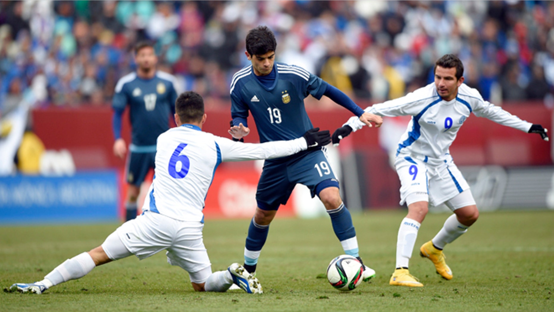 Argentina's Ever Banega battles for the ball against El Salvador's Richard Menjivar and Rafael Burgos, March 28, 2015.
