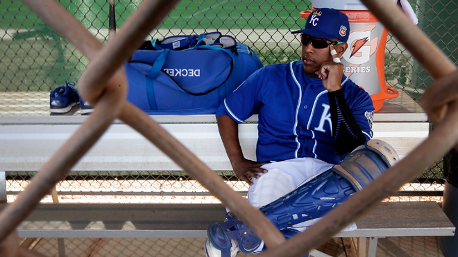 Kansas City Royals catcher Salvador Perez waits in a dugout before a drill during spring training baseball practice Tuesday, Feb. 23, 2016, in Surprise, Ariz. (AP Photo/Charlie Riedel)