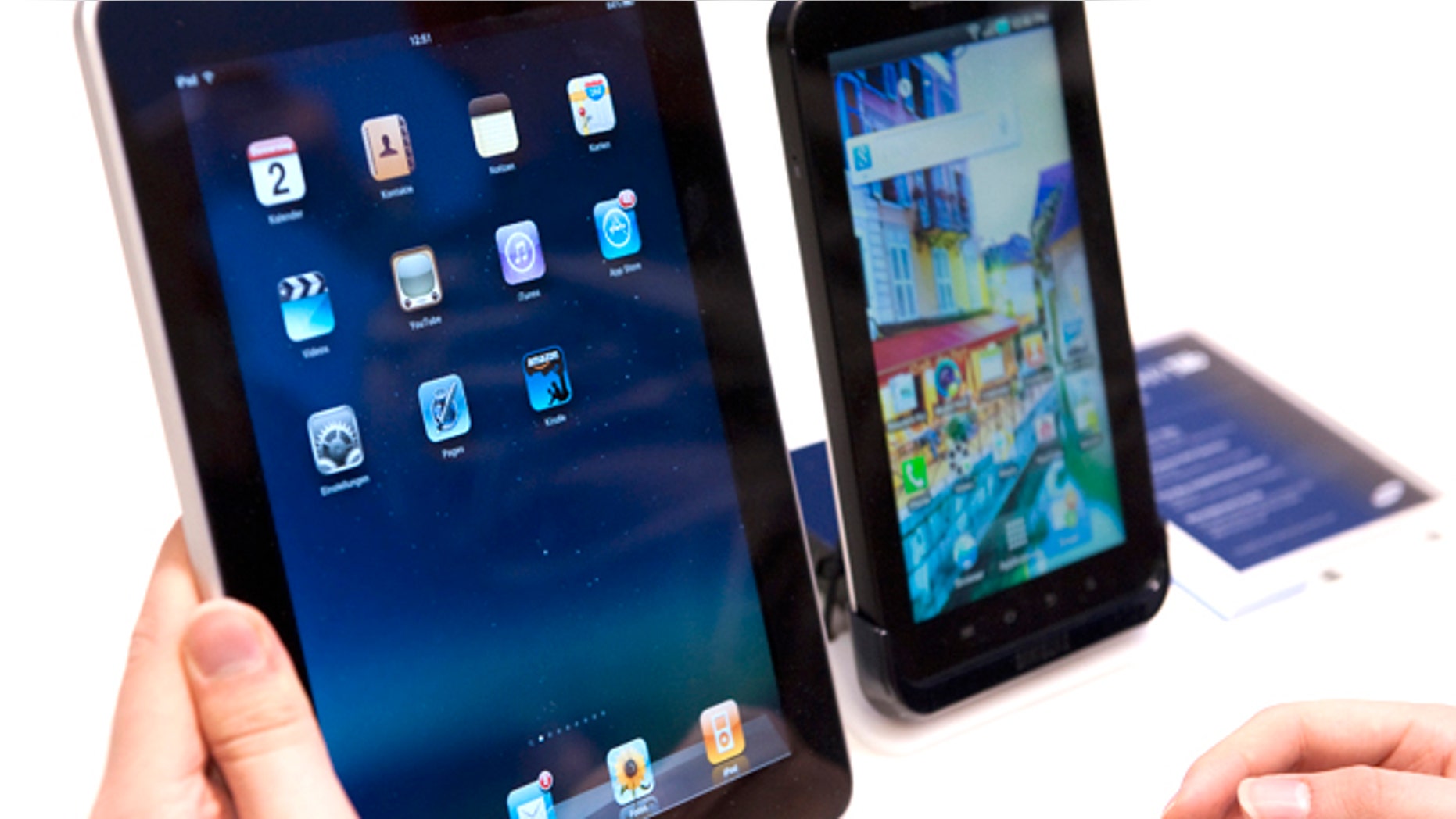 A journalist compares the new Samsung Galaxy Tab, right, a tablet computer to compete with the Apple iPad, left, at IFA, the world's largest trade fair for consumer electronics and electrical home appliances, in Berlin, Germany, Thursday, Sept. 2, 2010. IFA takes place from Sept. 3 to Sept. 8, 2010 on the Berlin Exhibition Grounds.