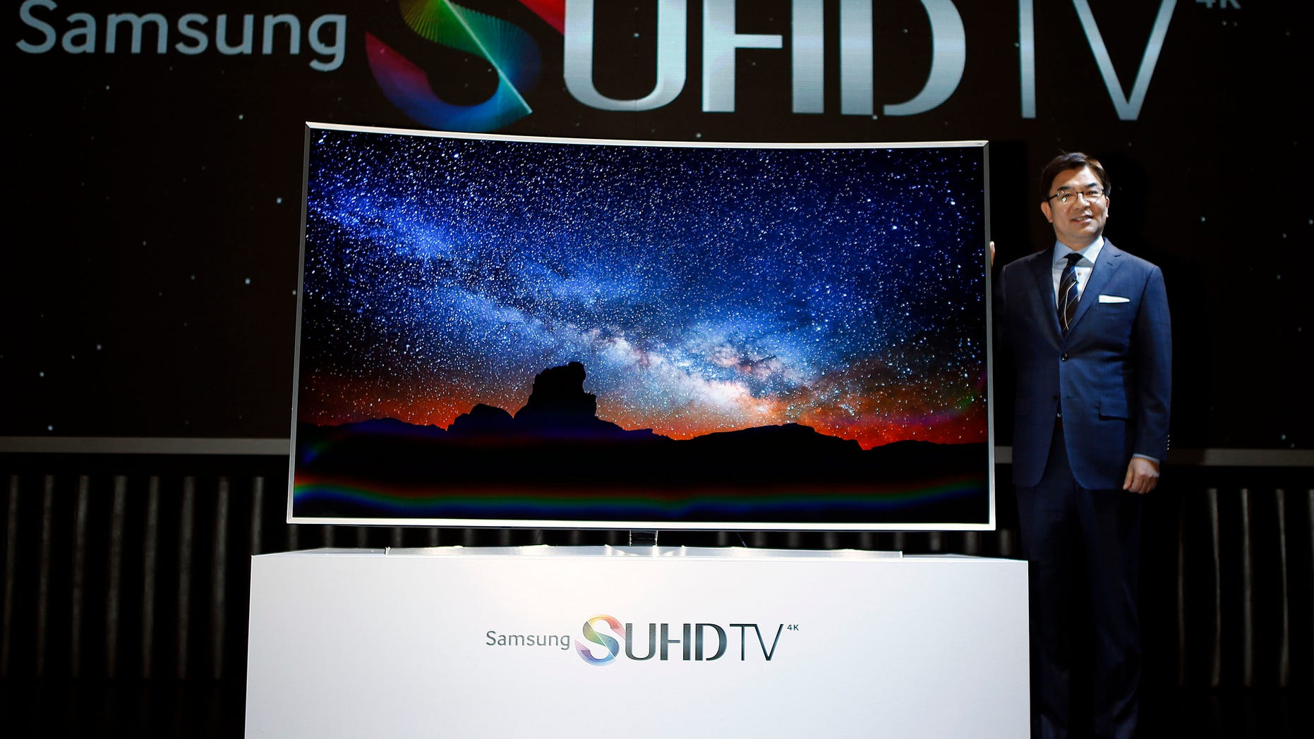 Kim Hyun-seok, head of Samsung Electronics television division, poses for photographs with a Samsung Electronics smart TV during its launch event in Seoul February 5, 2015.
