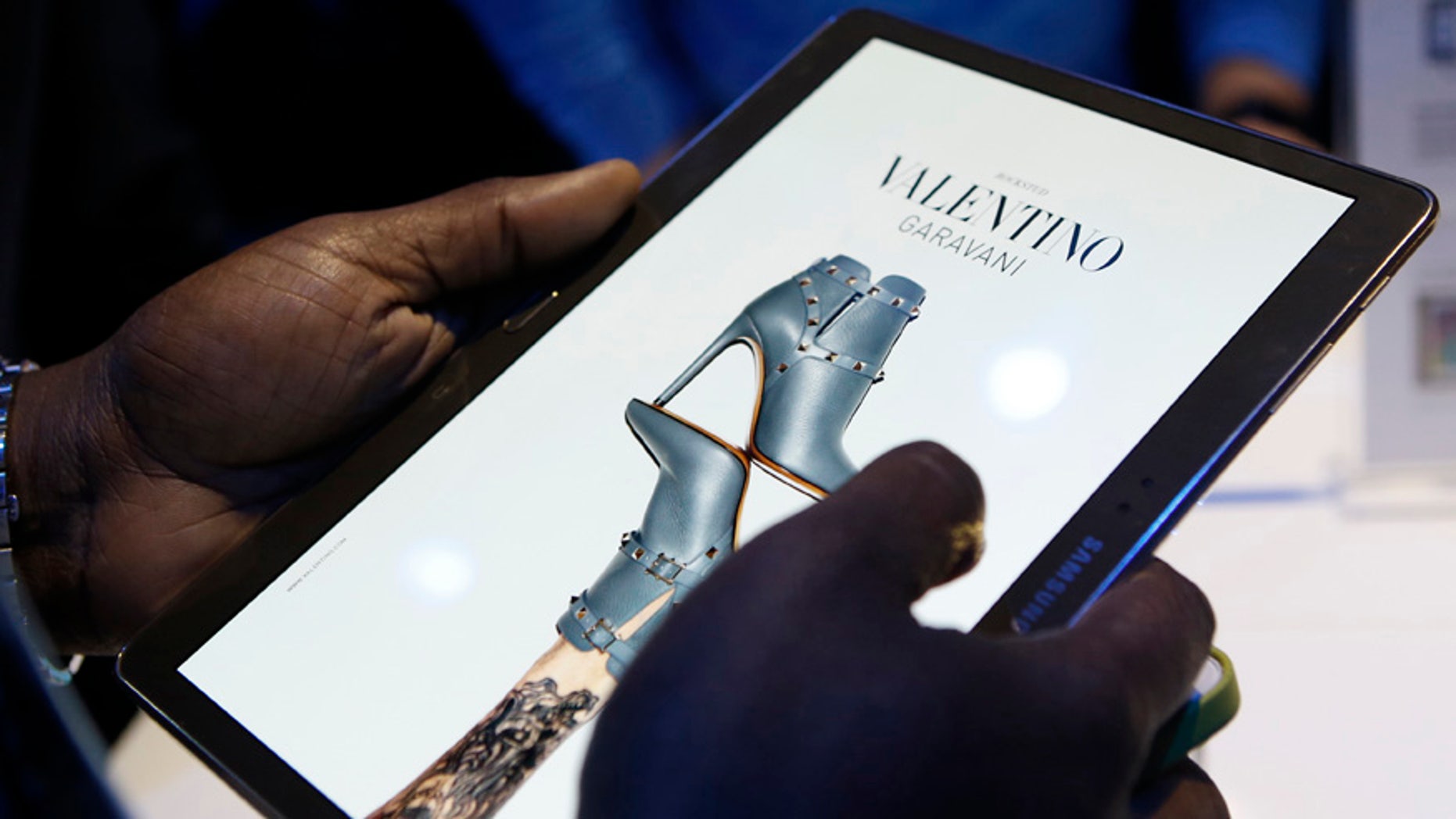 A member of the media scrolls through a fashion magazine during the debut of the Samsung Galaxy Tab S after the product's press debut in New York, Thursday, June 12, 2014.
