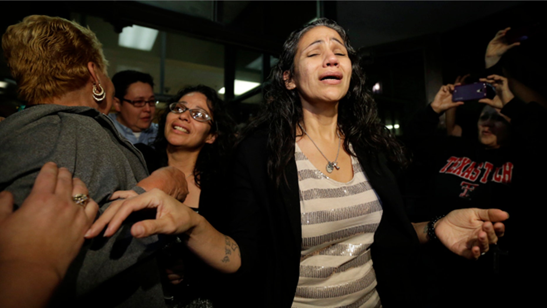 Cassandra Rivera, center, followed by Elizabeth Ramirez and Kristie Mayhugh are greeted by family as they leave the Bexar County Jail, Monday, Nov. 18, 2013, in San Antonio, after it was announced earlier in the day the San Antonio women imprisoned for sexually assaulting two girls in 1994 were expected to walk free Monday after a judge agreed that their convictions were tainted by faulty witness testimony. Vasquez, the fourth, has already been paroled, but under strict conditions. (AP Photo/Eric Gay)