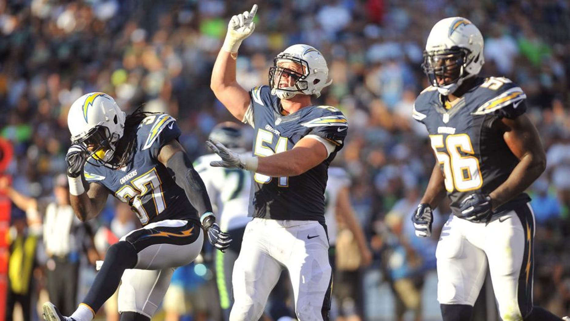Aug 29, 2015; San Diego, CA, USA; San Diego Chargers linebacker Kyle Emanuel (51) celebrates with defensive back Jahleel Addae (37) and inside linebacker Donald Butler (56) after sacking Seattle Seahawks quarterback Russell Wilson (not pictured) at Qualcomm Stadium. Mandatory Credit: Orlando Ramirez-USA TODAY Sports