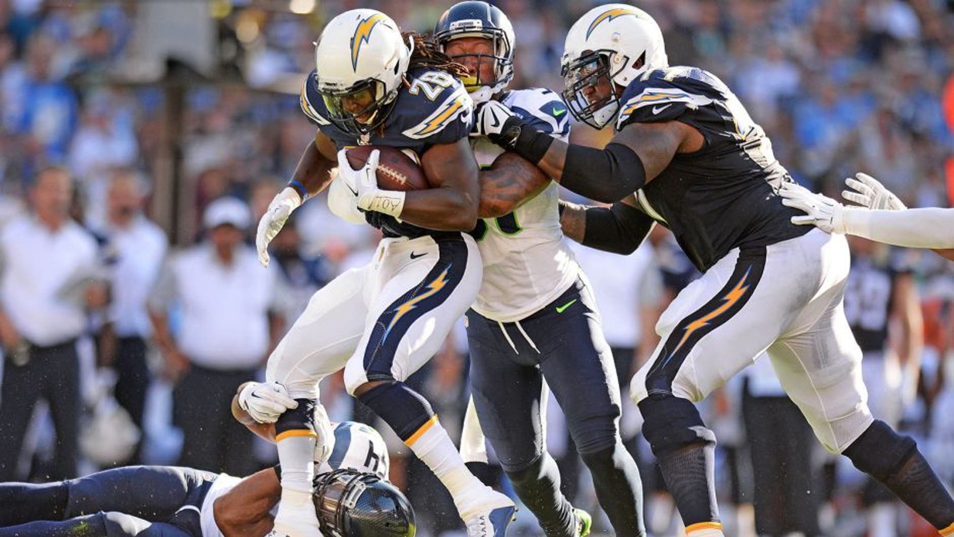 Aug 29, 2015; San Diego, CA, USA; San Diego Chargers running back Melvin Gordon (28) is tackled by Seattle Seahawks middle linebacker Bobby Wagner (54) and outside linebacker Bruce Irvin (51) during the first quarter as tackle King Dunlap (77) attempts to help at Qualcomm Stadium. Mandatory Credit: Jake Roth-USA TODAY Sports