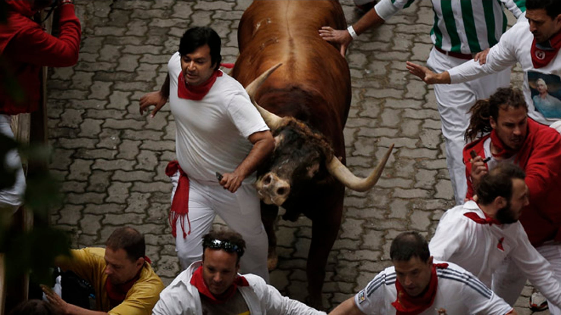 July 9, 2014: A Victoriano del Rio ranch fighting bull tosses a reveler during the running of the bulls of the San Fermin festival, in Pamplona, Spain.