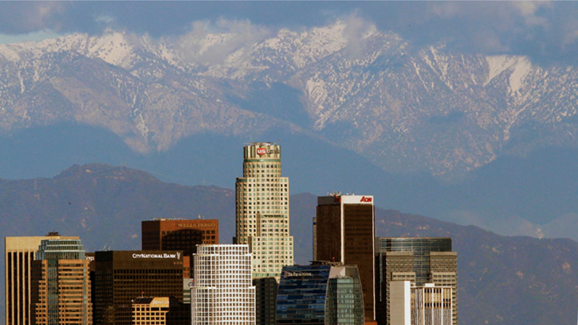FILE - In this Dec. 27, 2012 file photo, snow covered San Gabriel Mountains rise behind the downtown Los Angeles downtown skyline. President Barack Obama plans to announce on Friday, Oct. 10, 2014 that he will designate 346,000 acres within the San Gabriel Mountains as the nation's new national monument. (AP Photo/Nick Ut, File)