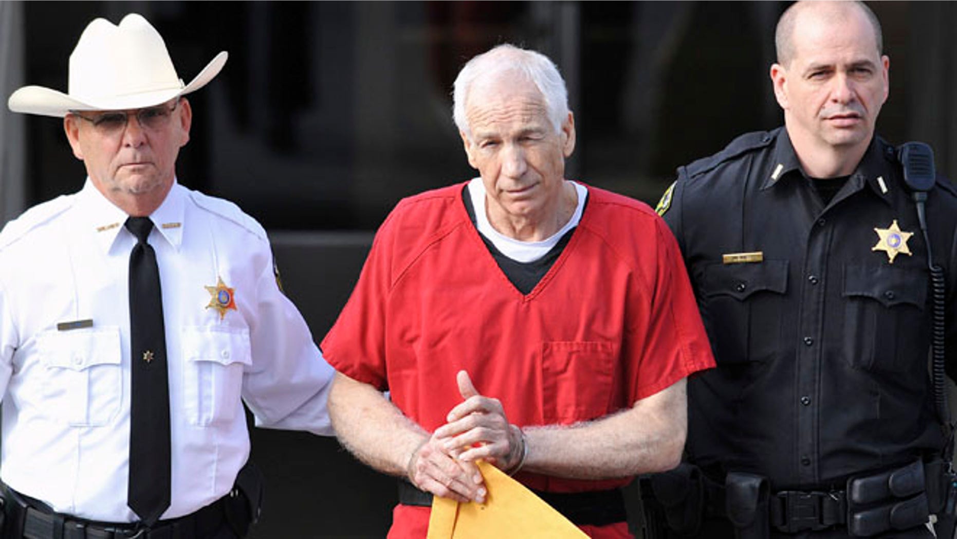 Oct 9, 2012: Jerry Sandusky (C) leaves the Centre County Courthouse after his sentencing in his child sex abuse case in Bellefonte, Pennsylvania.