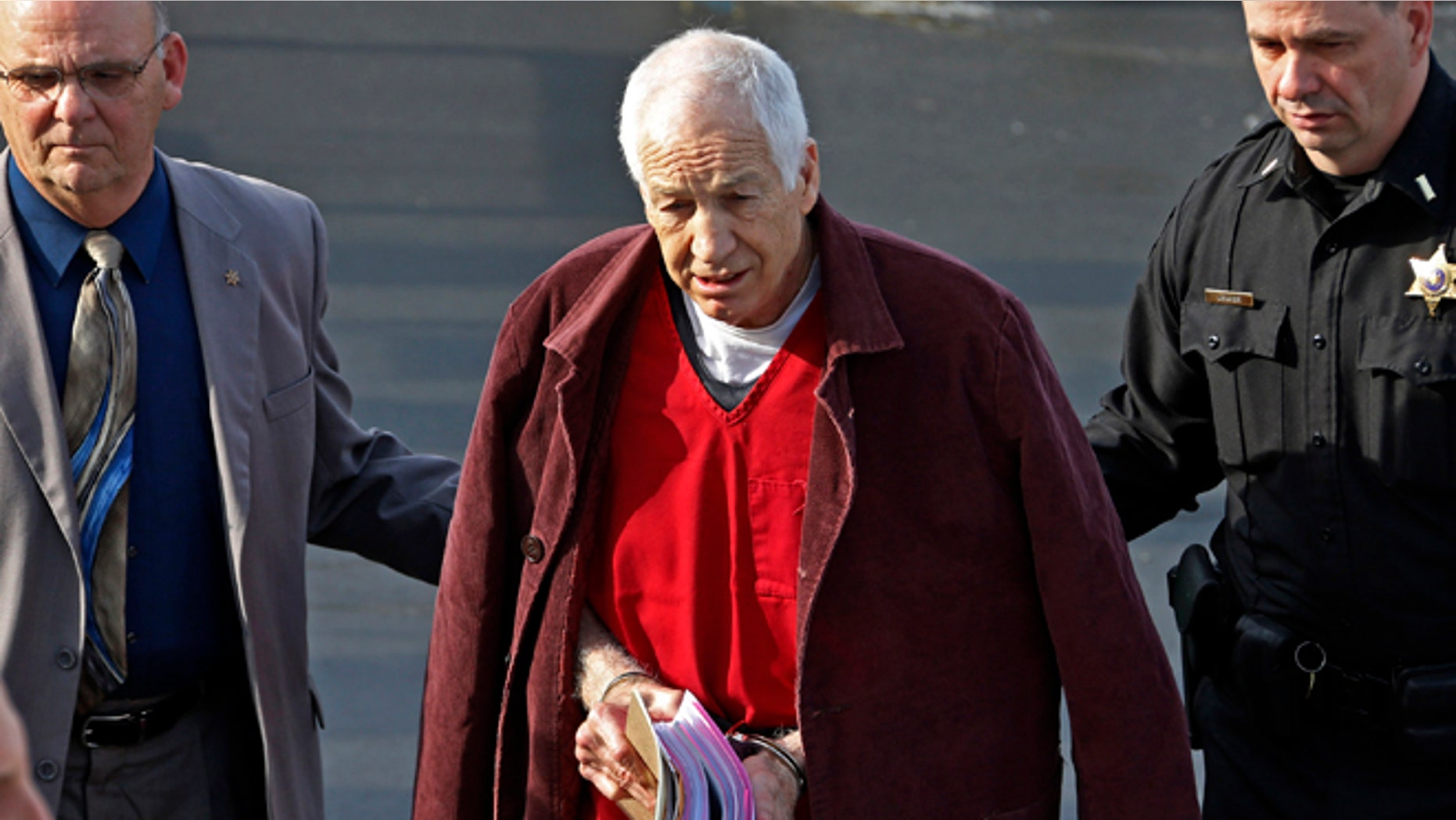 Jan. 10, 2013: Former Penn State University assistant football coach Jerry Sandusky, center, leaves the Centre County Courthouse after attending a post-sentence motion hearing in Bellefonte, Pa.
