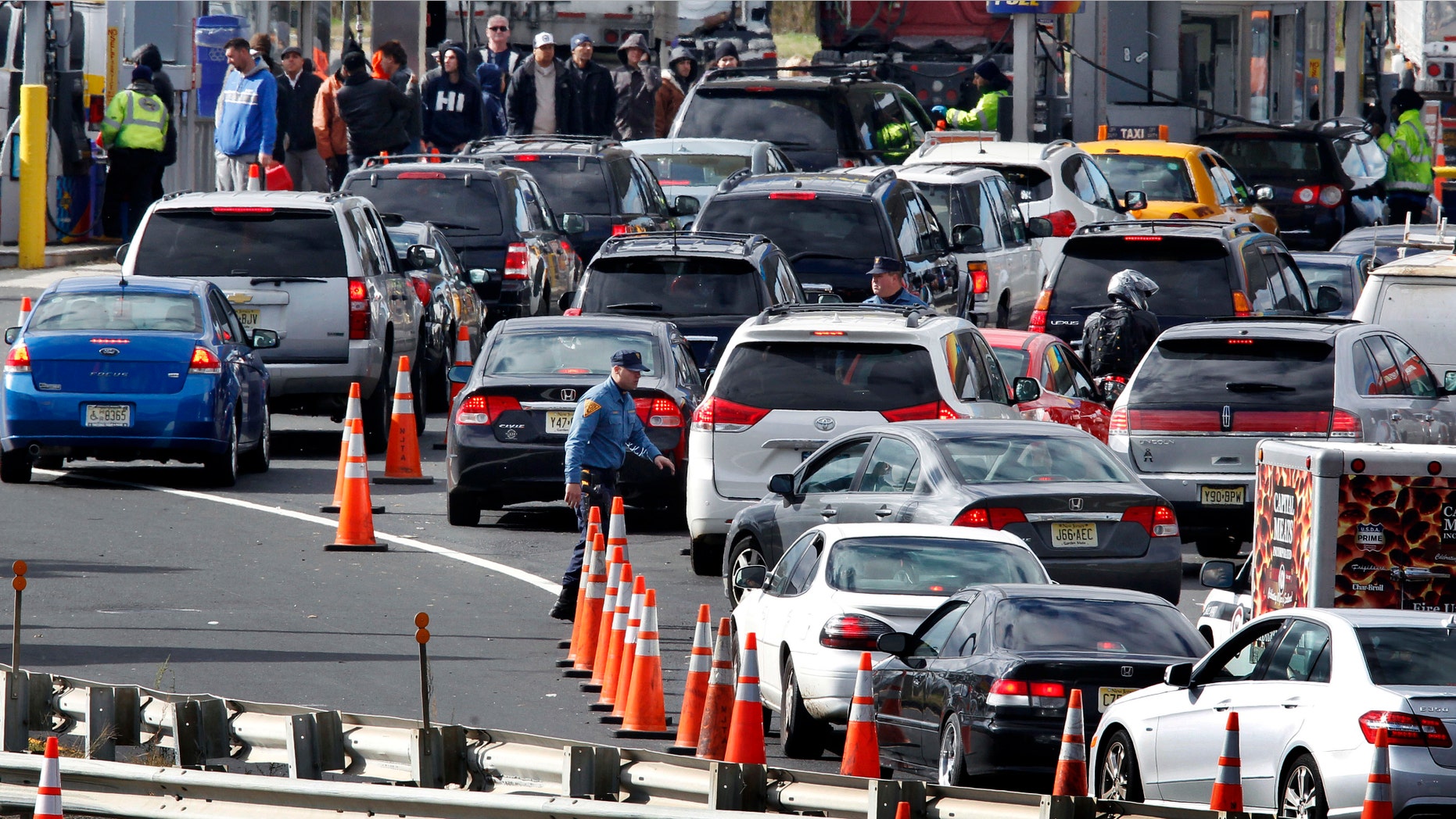 New Jersey state troopers keep order as motorists line up to purchase gasoline at the Thomas A. Edison service area on the New Jersey Turnpike, Saturday, Nov. 3, 2012, near Woodbridge, N.J. (AP Photo/Mel Evans)