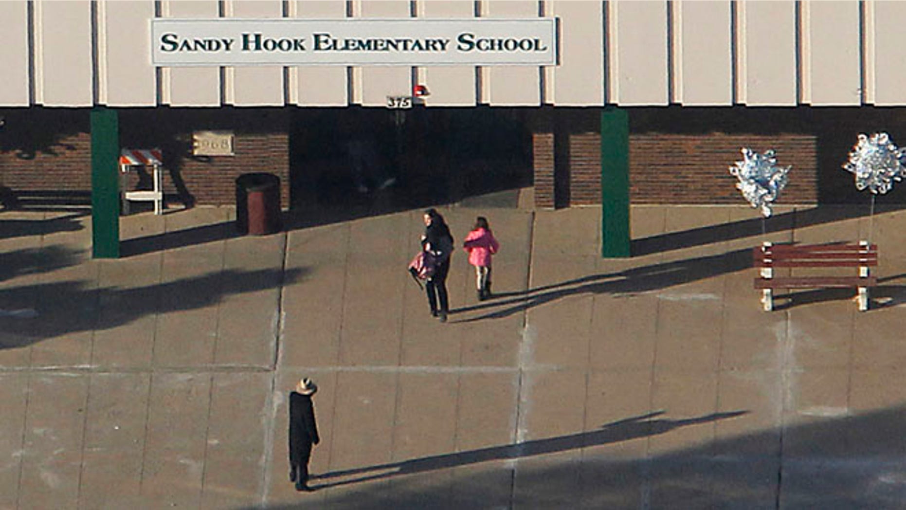 FILE 2013: A parent escorts her daughter into the former Chalk Hill School, a disused school refurbished specifically for the students from Newtown which now bears the name Sandy Hook Elementary School, in Monroe, Connecticut.