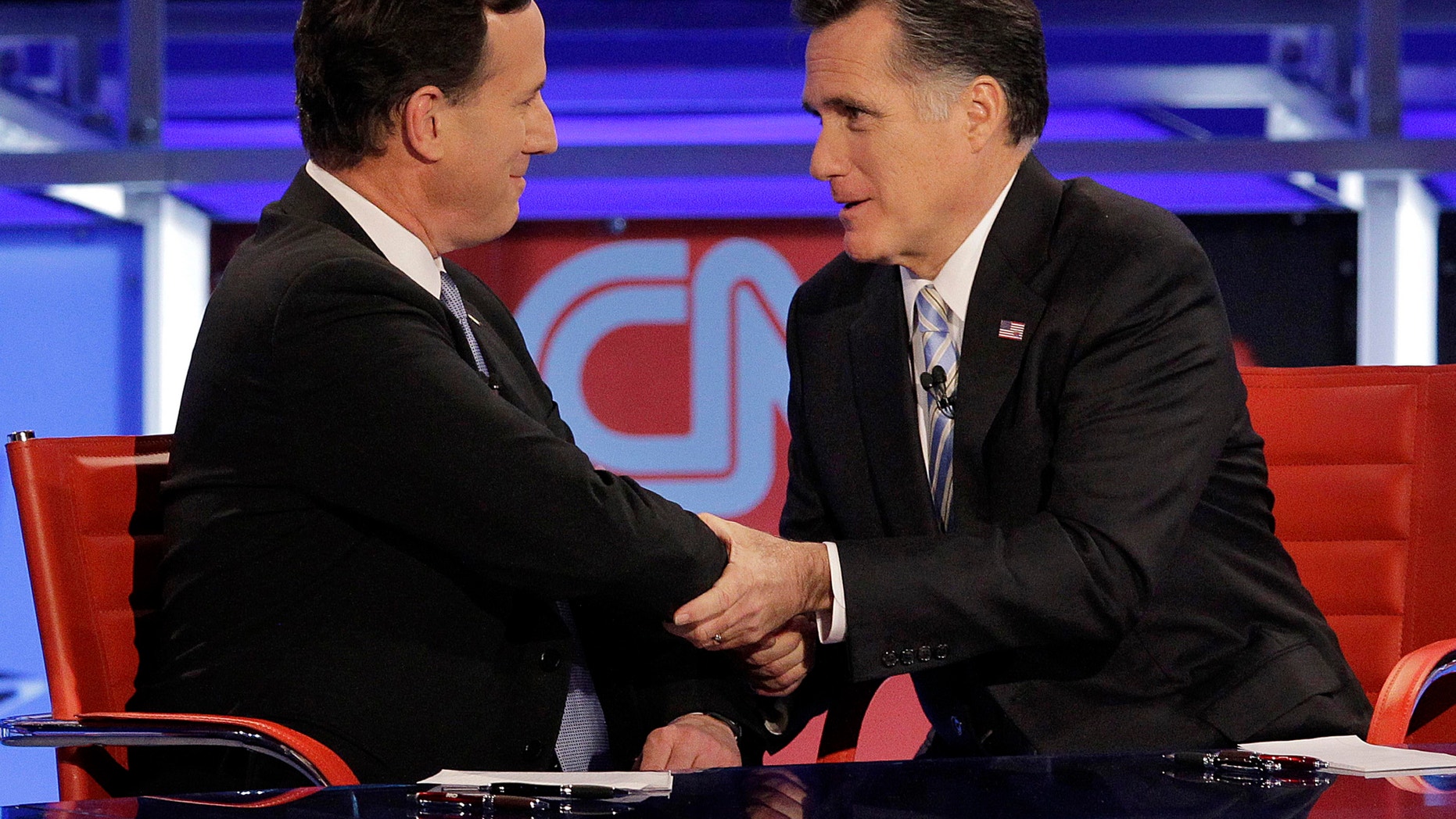 FILE: Republican presidential candidate and former Massachusetts Gov. Mitt Romney, right, talks with ex-candidate, former Pennsylvania Sen. Rick Santorum, left, after a presidential debate in Arizona.