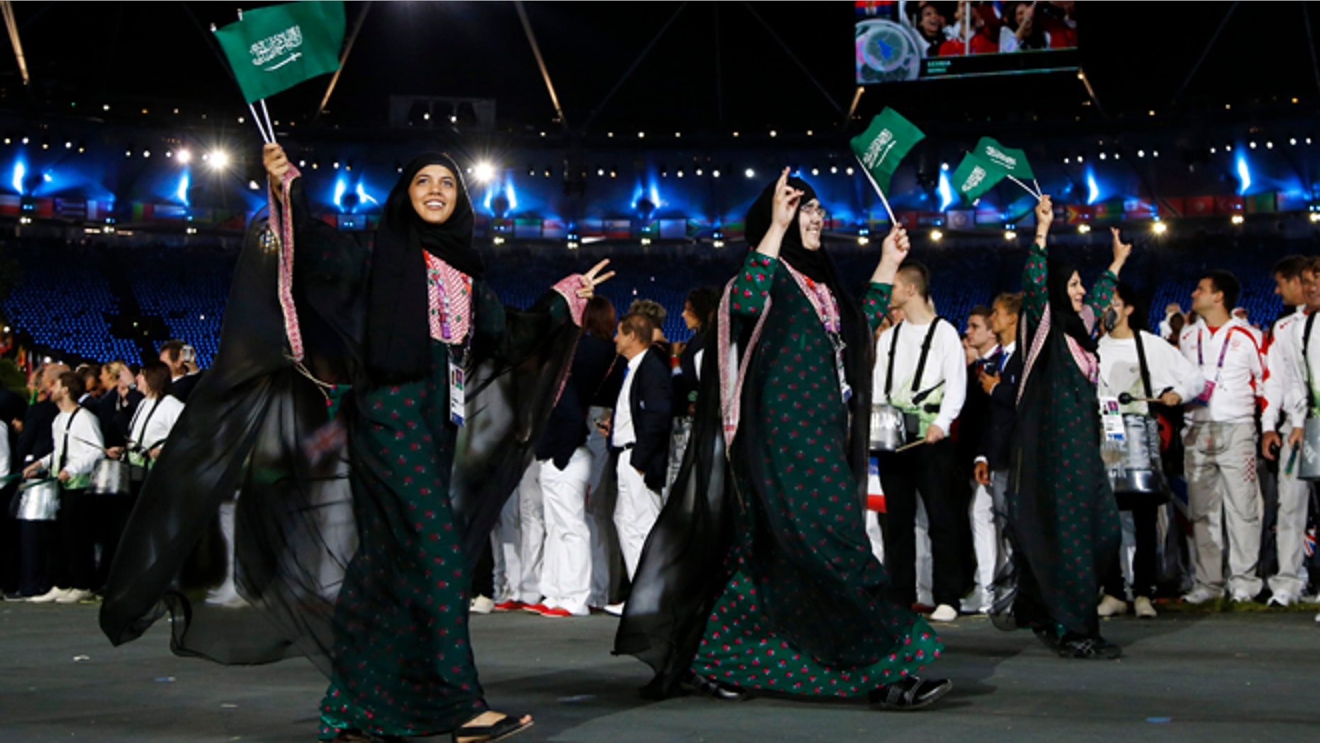July 27, 2012: Saudi Arabia's athletes parade, Wojdan Ali Seraj Abdulrahim Shaherkani , center, during the Opening Ceremony at the 2012 Summer Olympics, in London.