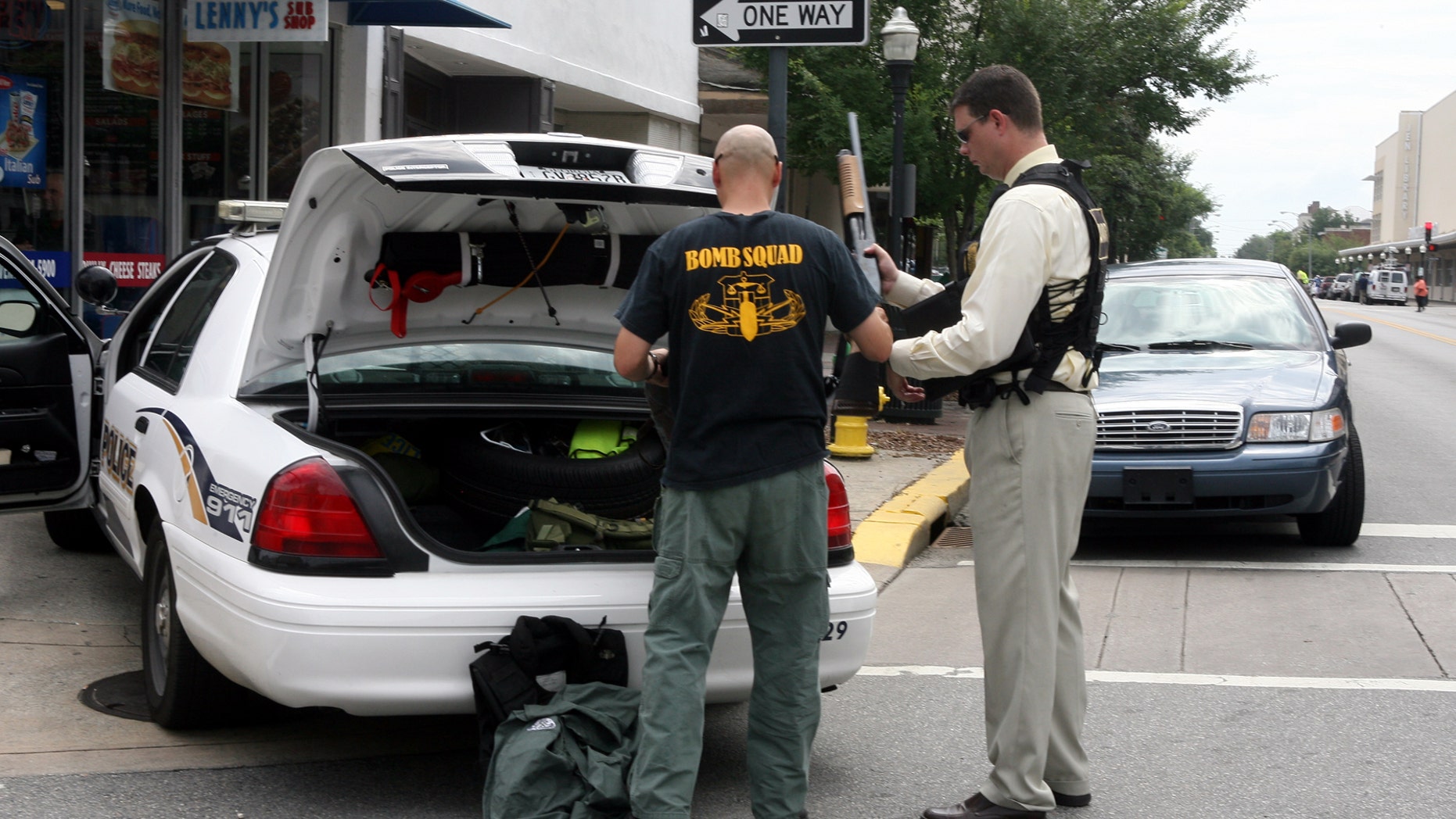 May 17: A bomb squad office and a hostage negotiator return a weapon to the trunk of the patrol car after a search for a gunman who was barricaded inside the landmark Pink House restaurant in Savannah, Ga.