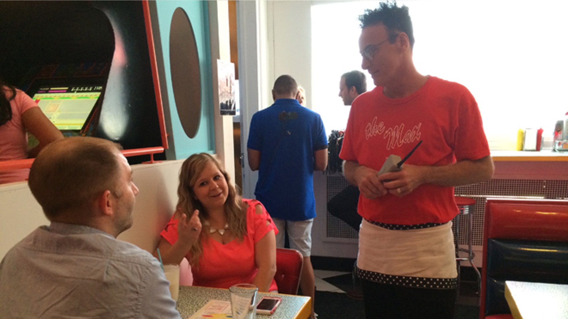 In this Wednesday, June 1, 2016 photo, original "Saved by the Bell" castmember Ed Alonzo, right, talks to Steve Gross and Tiffany Gross at pop-up restaurant Saved by the Max in Chicago. A vacant restaurant space in Chicagoâs Wicker Park neighborhood has become a replica of The Max, the fictitious hangout from the TV sitcom "Saved by the Bell." (AP Photo/Terry Tang)