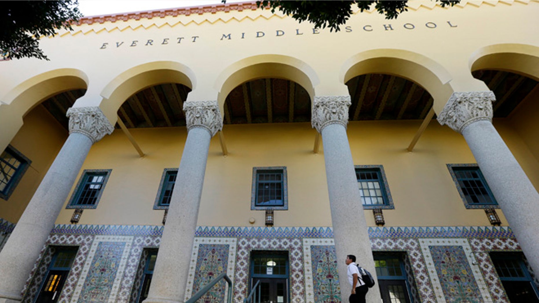 An unidentified boy walks outside Everett Middle School in San Francisco, Tuesday, Oct. 20, 2015. A student election at a mostly black and Hispanic middle school turned into a fierce debate about the democratic process when the school's principal delayed announcing the election results over concerns they did not reflect the school's diverse student body. (AP Photo/Jeff Chiu)